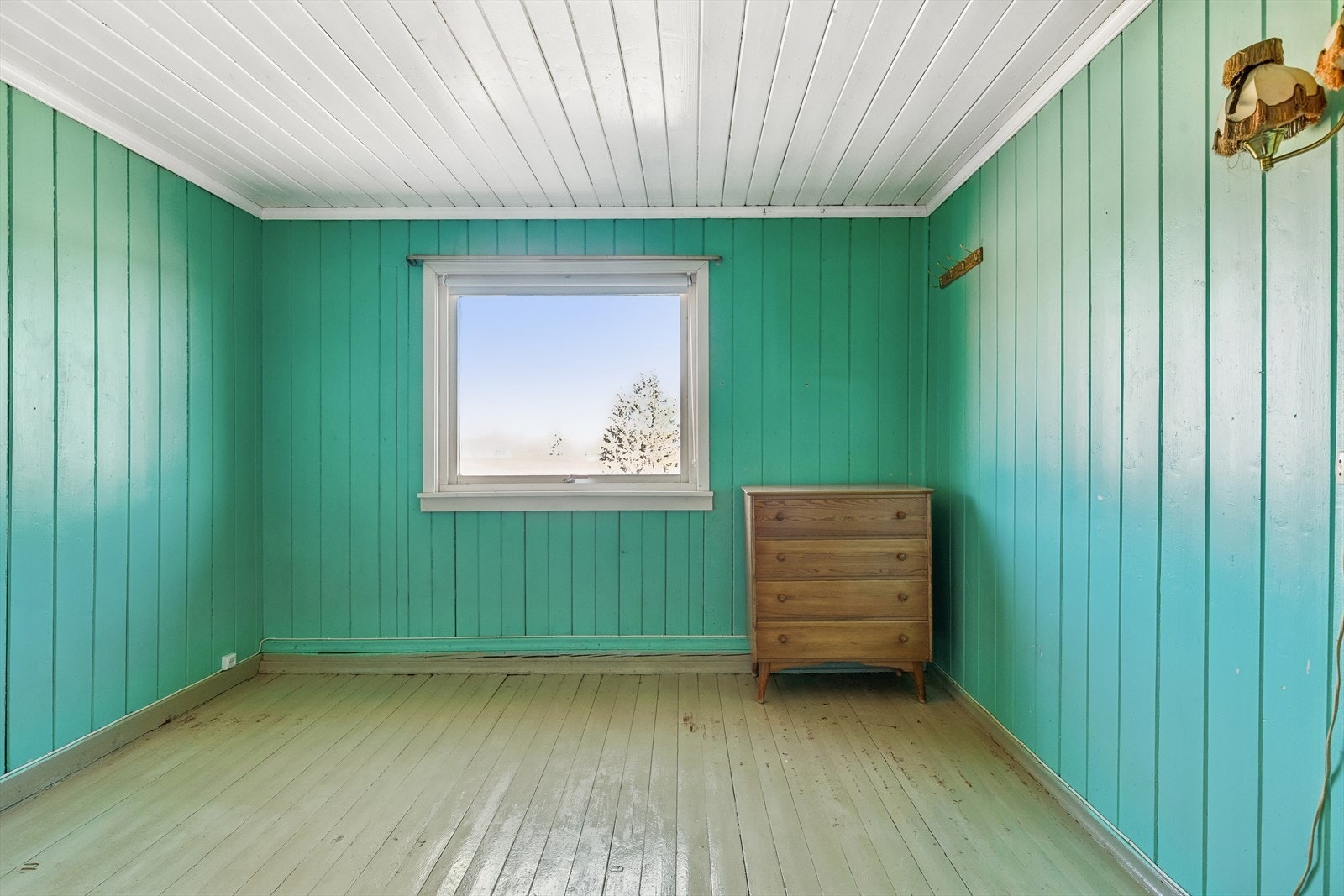 Det ene soverommet har et solid heltregulv og vegger kledd i trepanel. Galleribilde