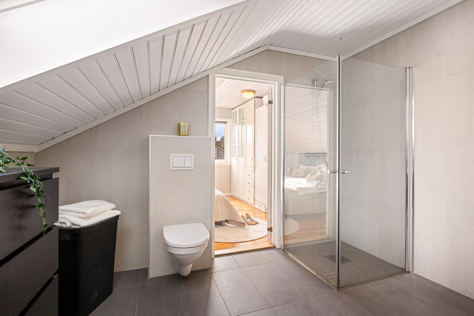 Badet har en stilren utførelse og romslig dusj Galleribilde