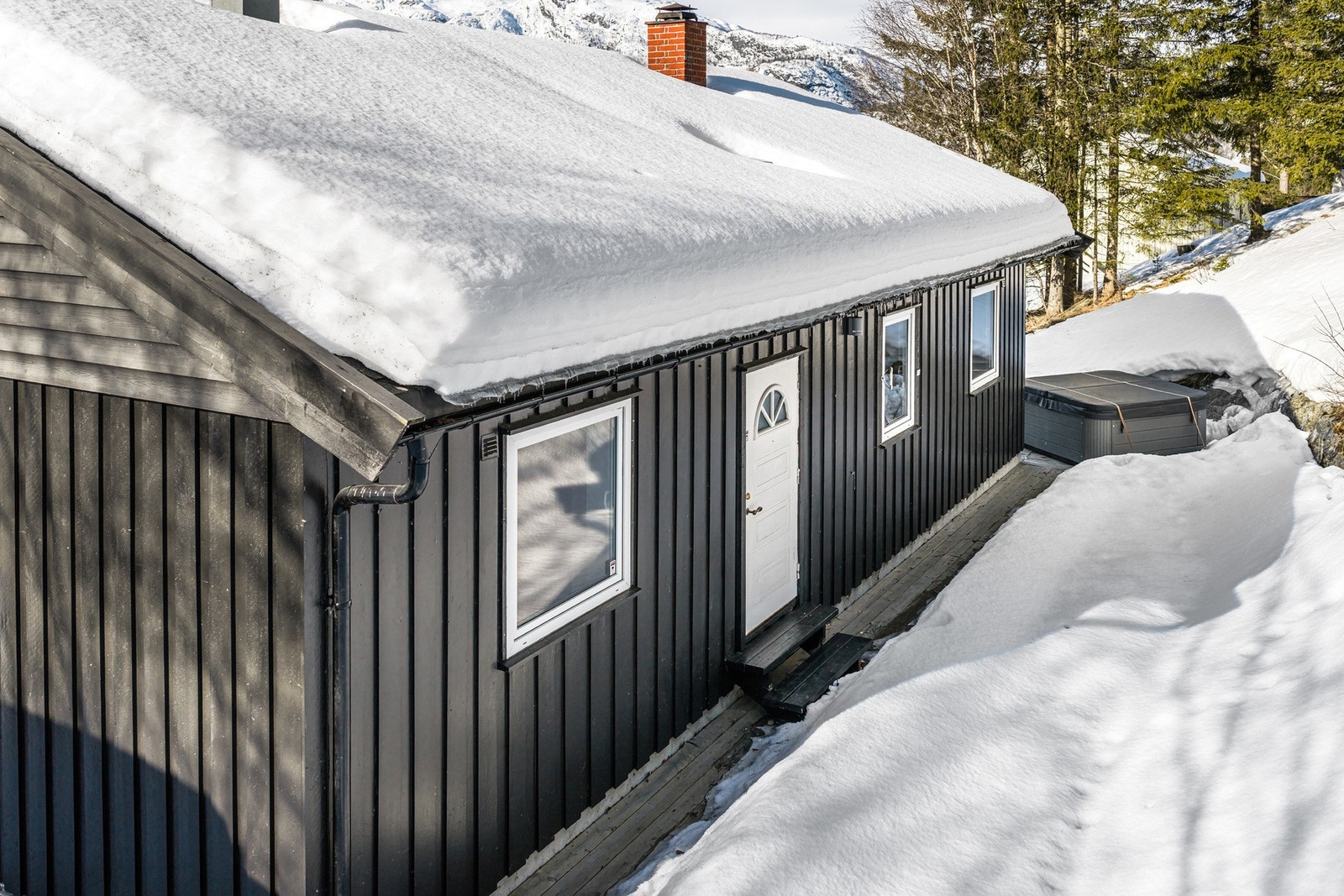 På nordsiden av boligen er det opparbeidet større terrasse, utendørs boblebad og adkomst til uthus. Galleribilde