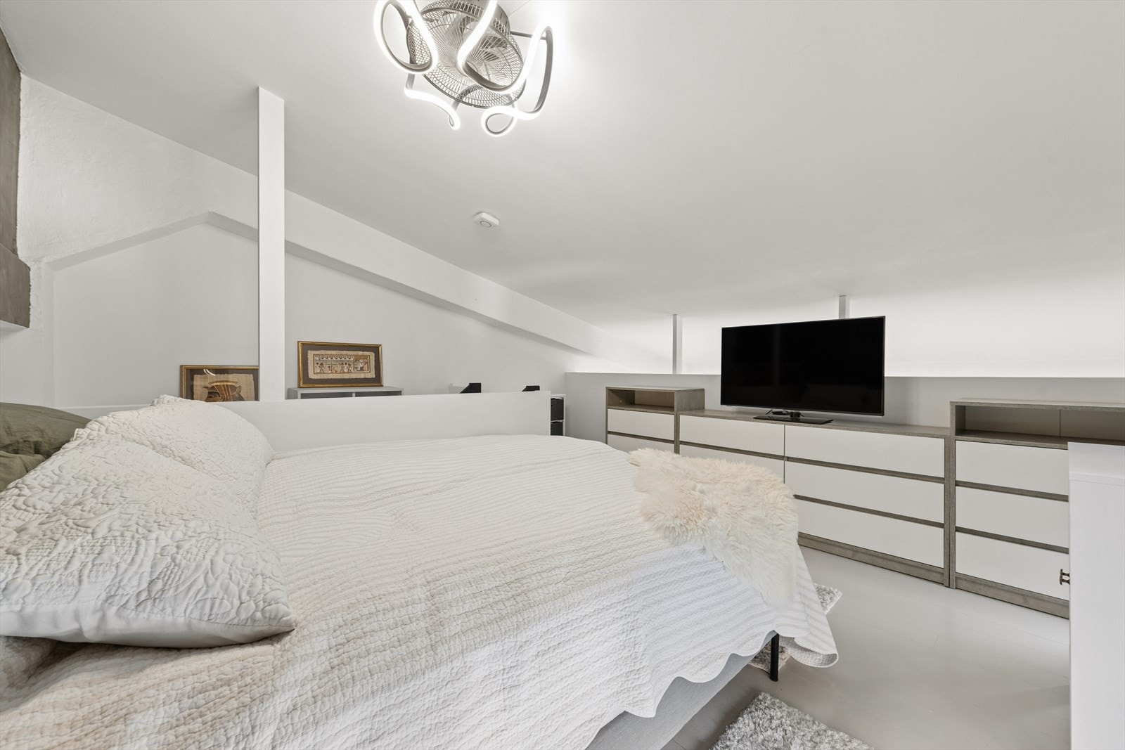 Plass til oppbevaring og møblering gjør hemsen til et fleksibelt rom. Bak vegg med plass til kommoder er det åpent ned til stuedelen. Galleribilde