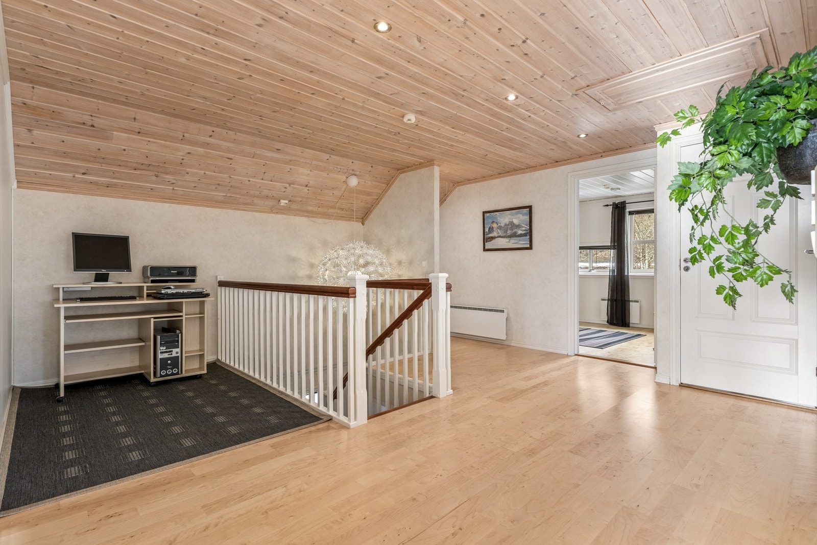 Trappen i entréen leder opp til en lys og romslig loftstue som fordeler seg ut til etasjens øvrige rom. Galleribilde