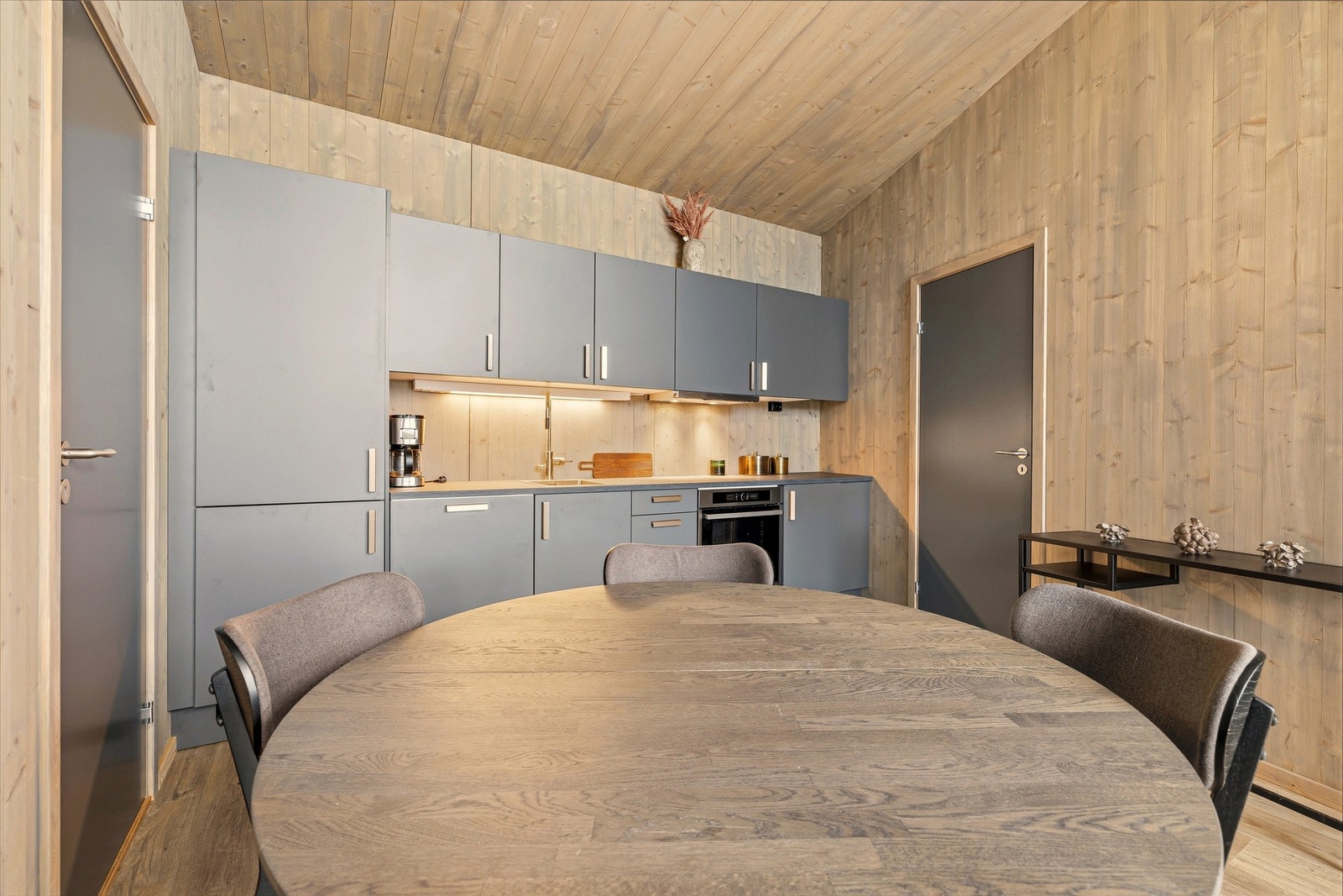 Kjøkkenet inkuderer et kombinert kjøleskap og fryser, en oppvaskmaskin, platetopp og en ovn. Galleribilde