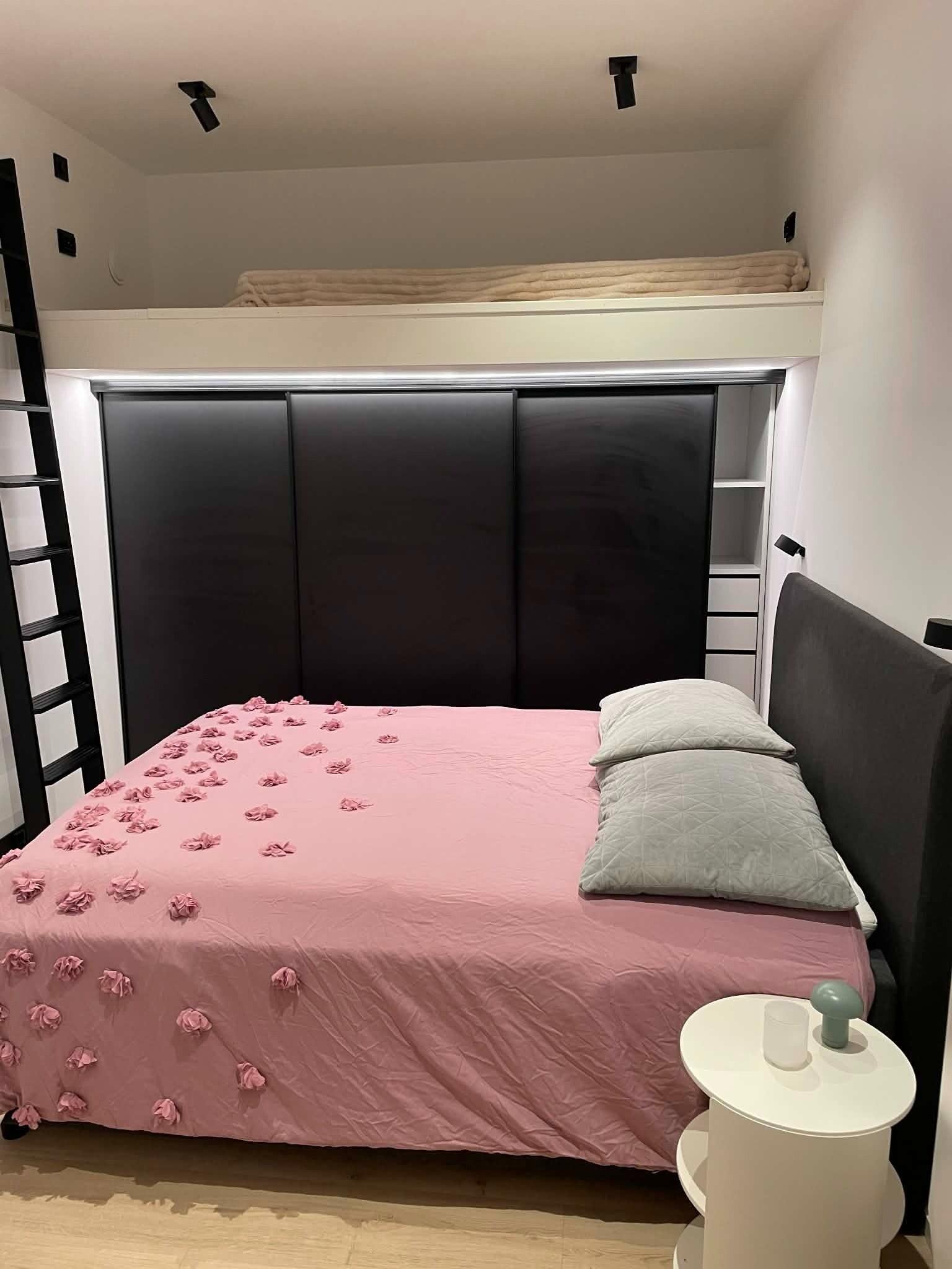 Soverom med stor skyvedørsgarderobe samt dobbeltseng med oppbevaring og hems. Galleribilde