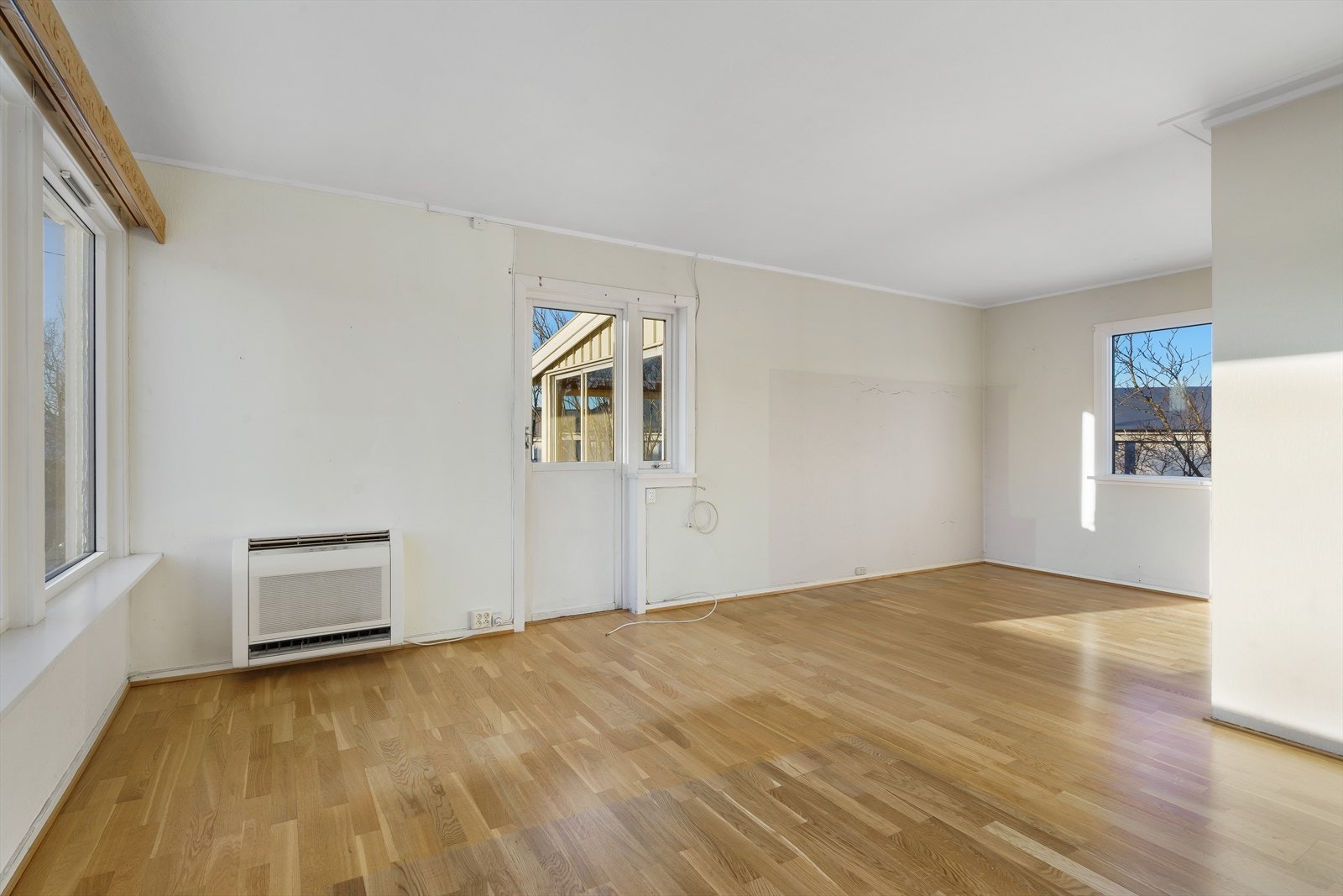 Det er montert en luft-til-luft-varmepumpe på vestveggen ved siden av verandadøren. Det er pipeløp i stuen, men dette er ikke tilkoblet vedovn i denne etasjen. Galleribilde