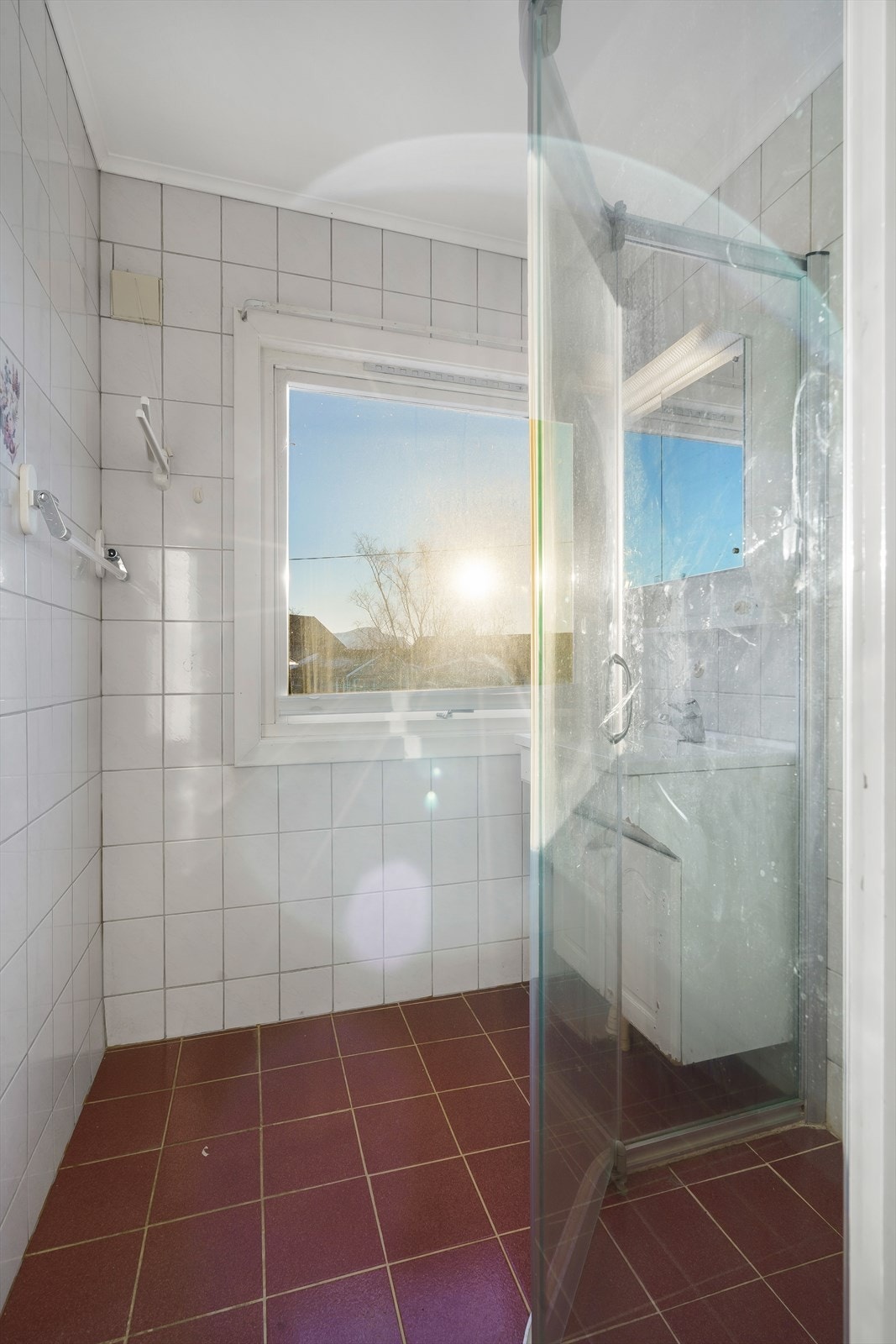 Dusjhjørne med dusjvegger og armatur på vegg, samt baderomsinnredning med underskap, servant, overskap med speil og belysning. Galleribilde