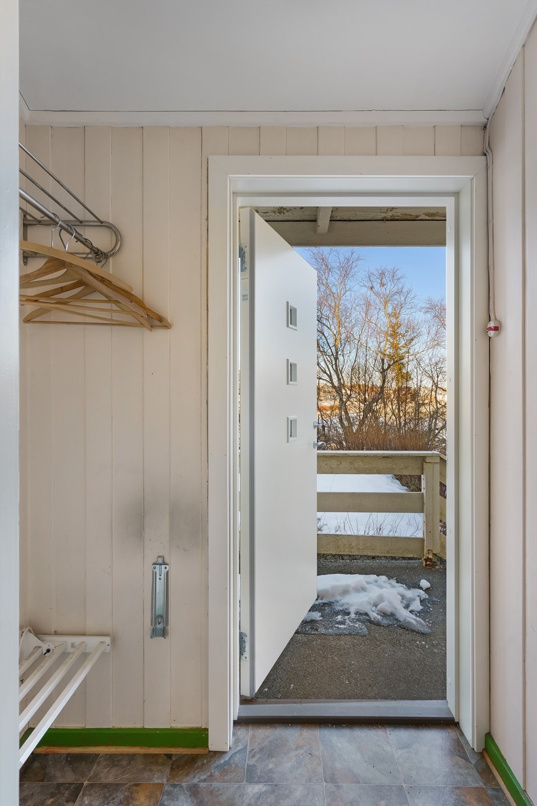 Du kommer inn til et vindfang med oppheng for klær og videre inngang til en gang som binder rommene i etasjen sammen. Galleribilde