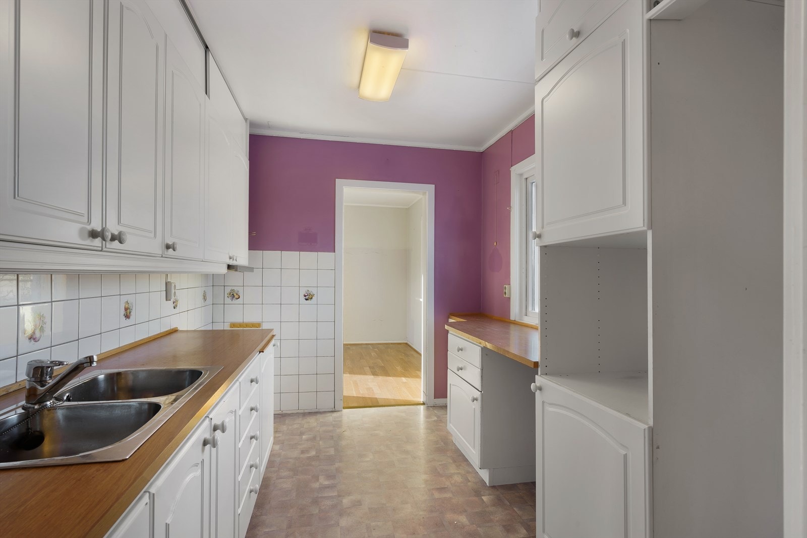 Eldre kjøkkeninnredning med profilerte fronter og laminert benkeplate. Galleribilde