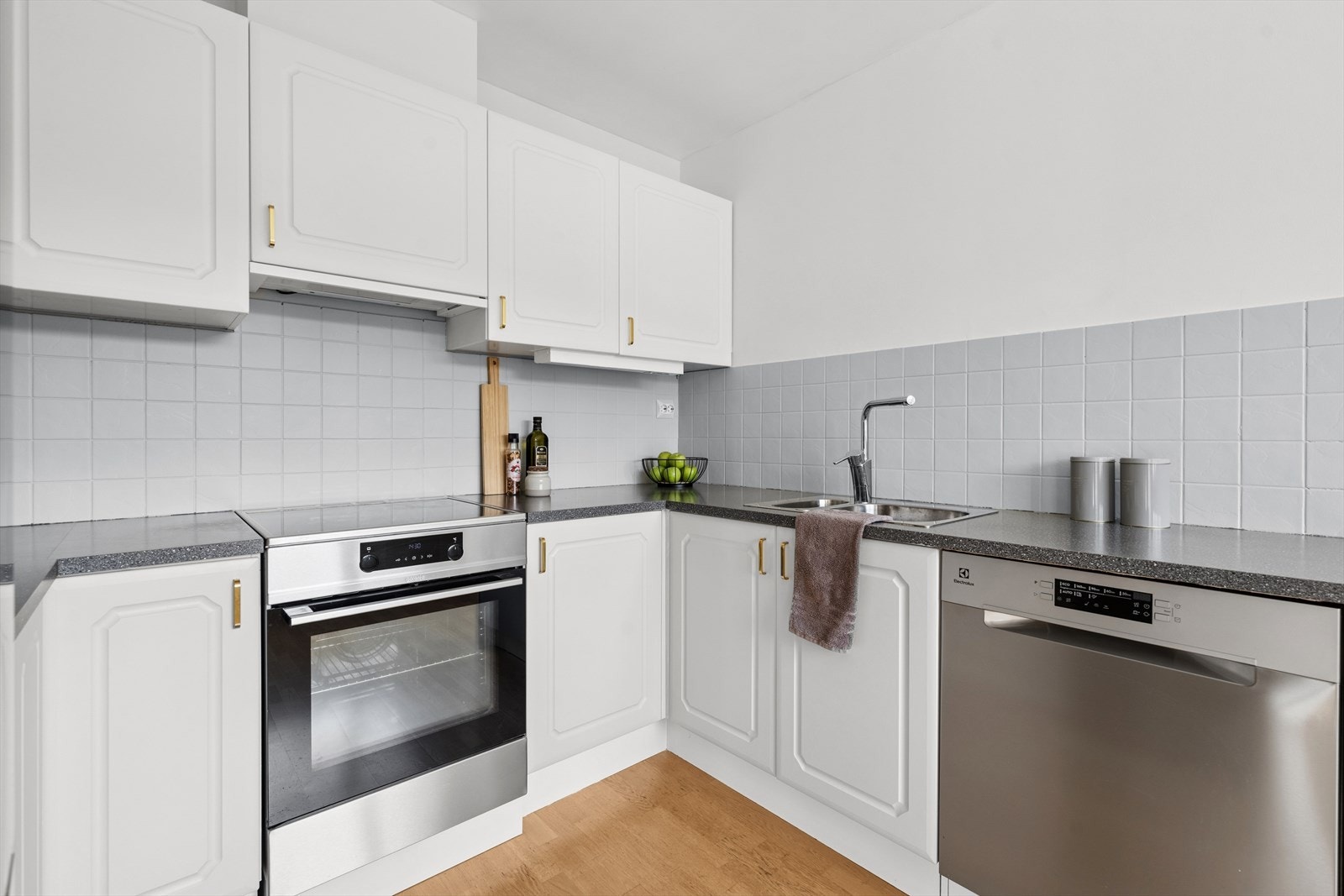 Fliser bak kjøkkenbenken gjør det praktisk å holde det rent med mat- og vannsøl. Kjøkkenet er ellers utstyrt med frittstående hvitevarer og har kjøkkenventilator med avtrekk ut. Galleribilde