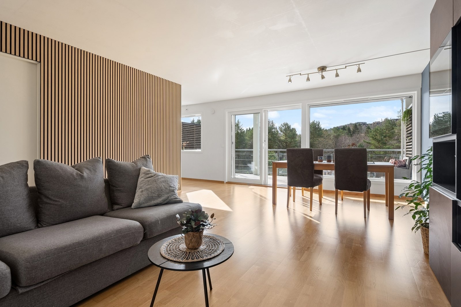 Boligens sosiale sone med stue og kjøkken ligger i delvis åpen løsning. Et lyst og innbydende rom med store vindusflater som gir rikelig med naturlig lys og flott utsikt over grøntområdene utenfor. Galleribilde