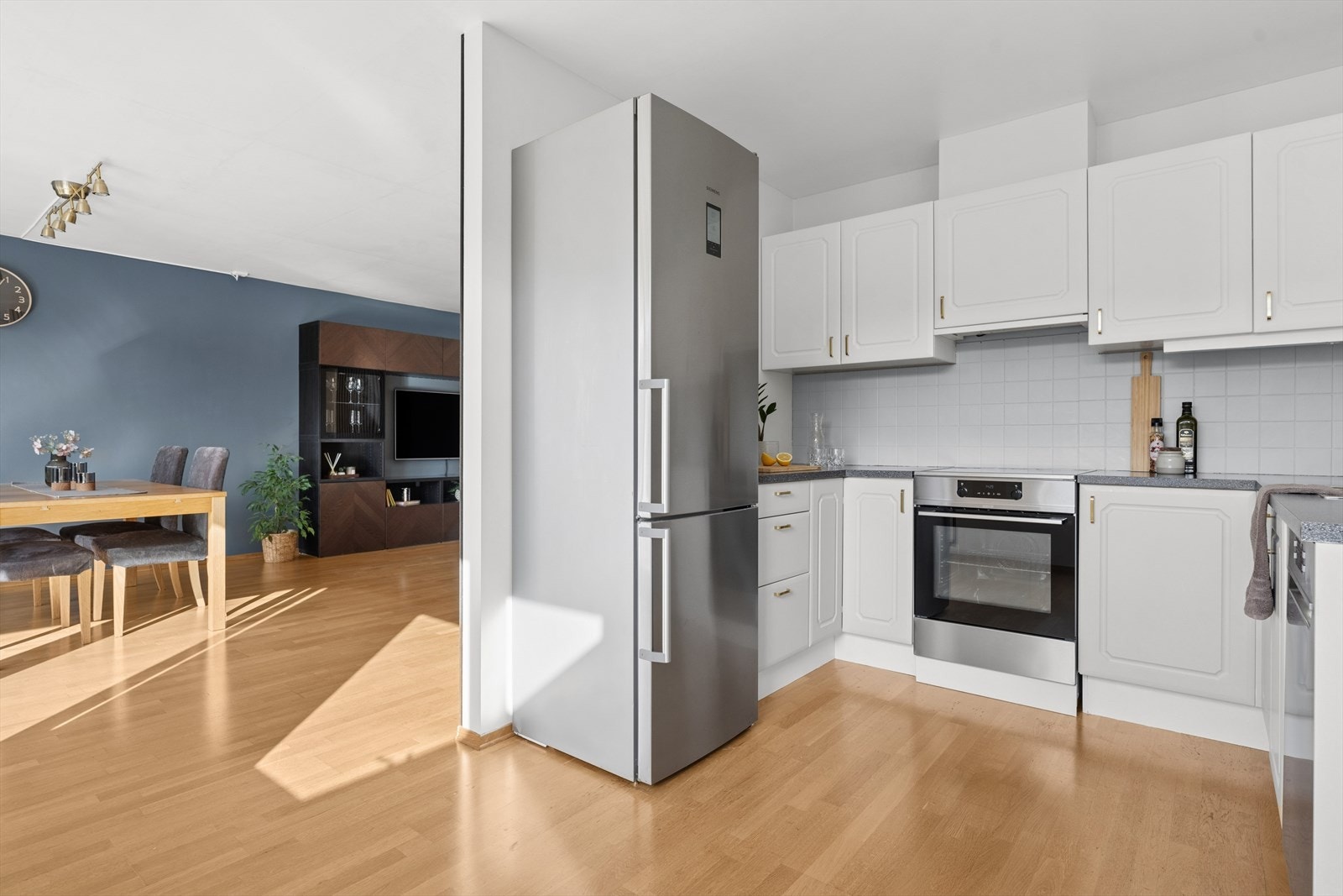 Kjøkkenet er tidløst innredet med hvite, profilerte fronter og grå benkeplate i laminat. Et praktisk kjøkken som gir godt med skap- og skuffeplass, samt gode arbeidsflater på benk. Galleribilde