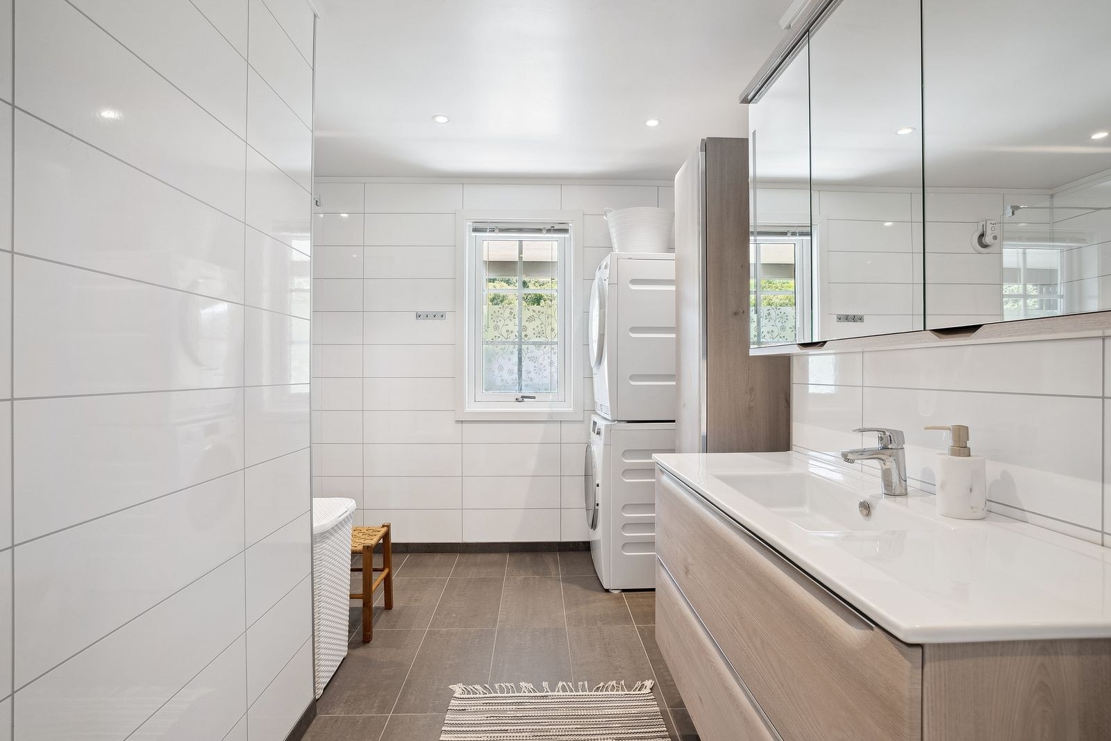 Flislagt gulv med termostatstyrte varmekabler gir komfort på baderommet. Badet ble renovert i 2021 og har spotter, dusjsone og elektrisk avtrekk. Galleribilde