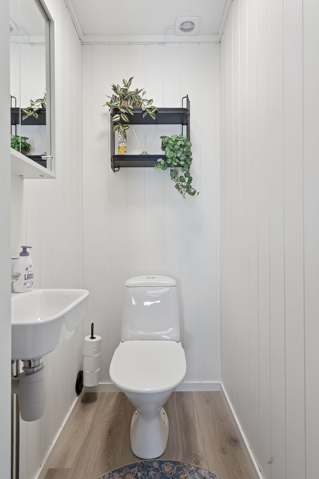 Toalettrommet har laminatgulv og vegger med malte plater. Galleribilde