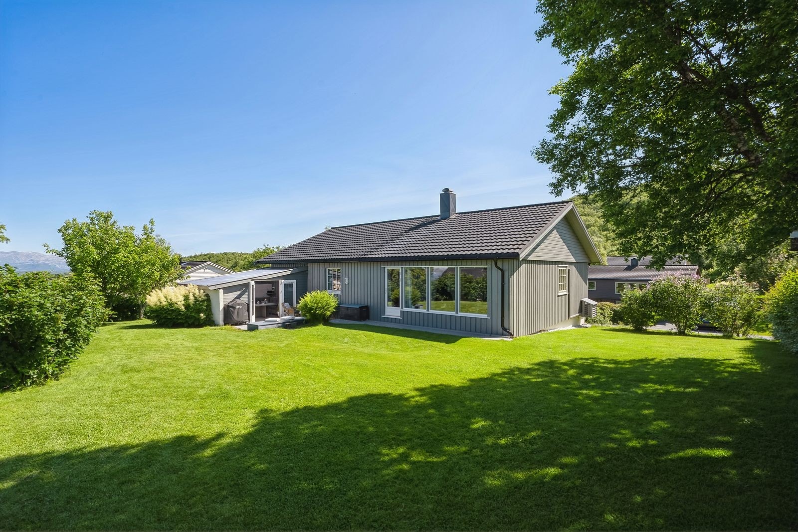 Velkommen til Huldreveien 29 - eiendommen har en opparbeidet tomt med plen og prydbusker, samt gruset innkjørsel. Utestue i tilknytning til terrassen som for øvrig er etablert mot utsikten. Galleribilde