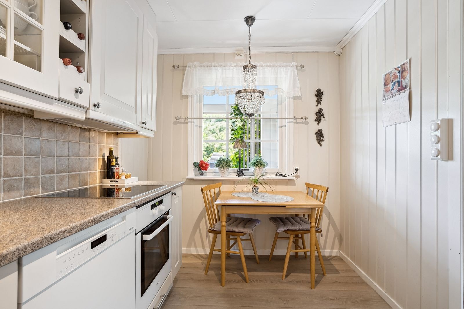 Spiseplass ved vinduet gir naturlig lys og utsyn til hageområde. Kjøkkenet har integrerte hvitevarer og har kort vei mellom arbeidssonene. Galleribilde