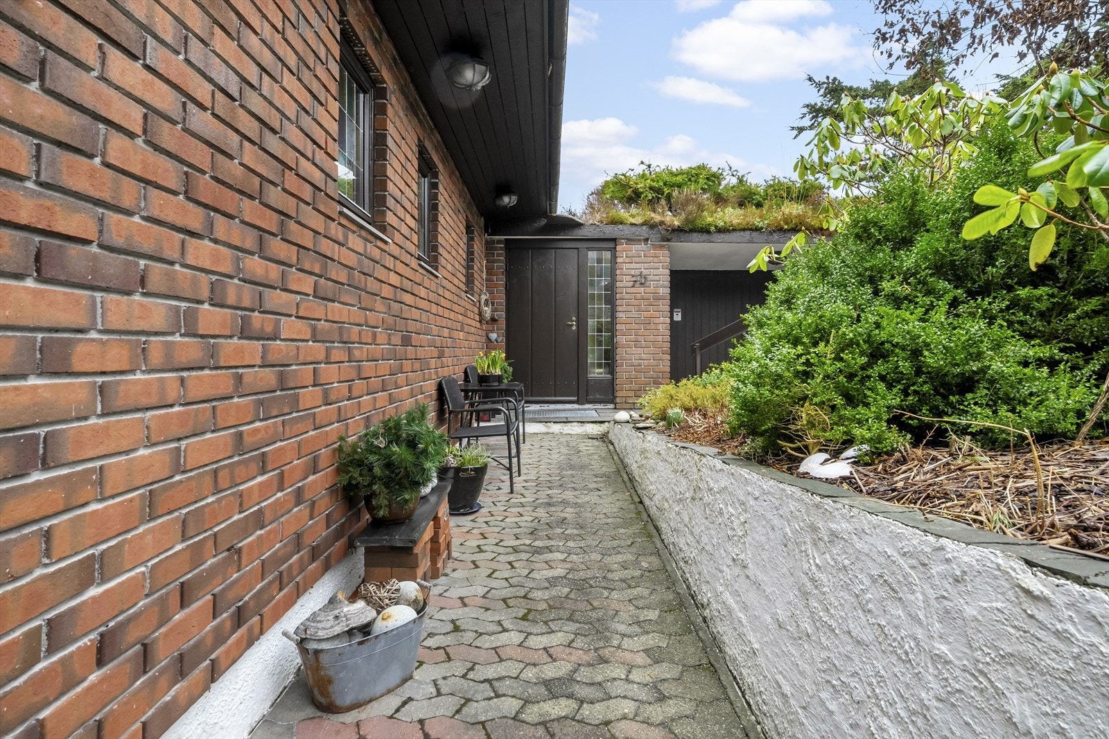 Boligen er omkranset av steinlagte gangstier Galleribilde