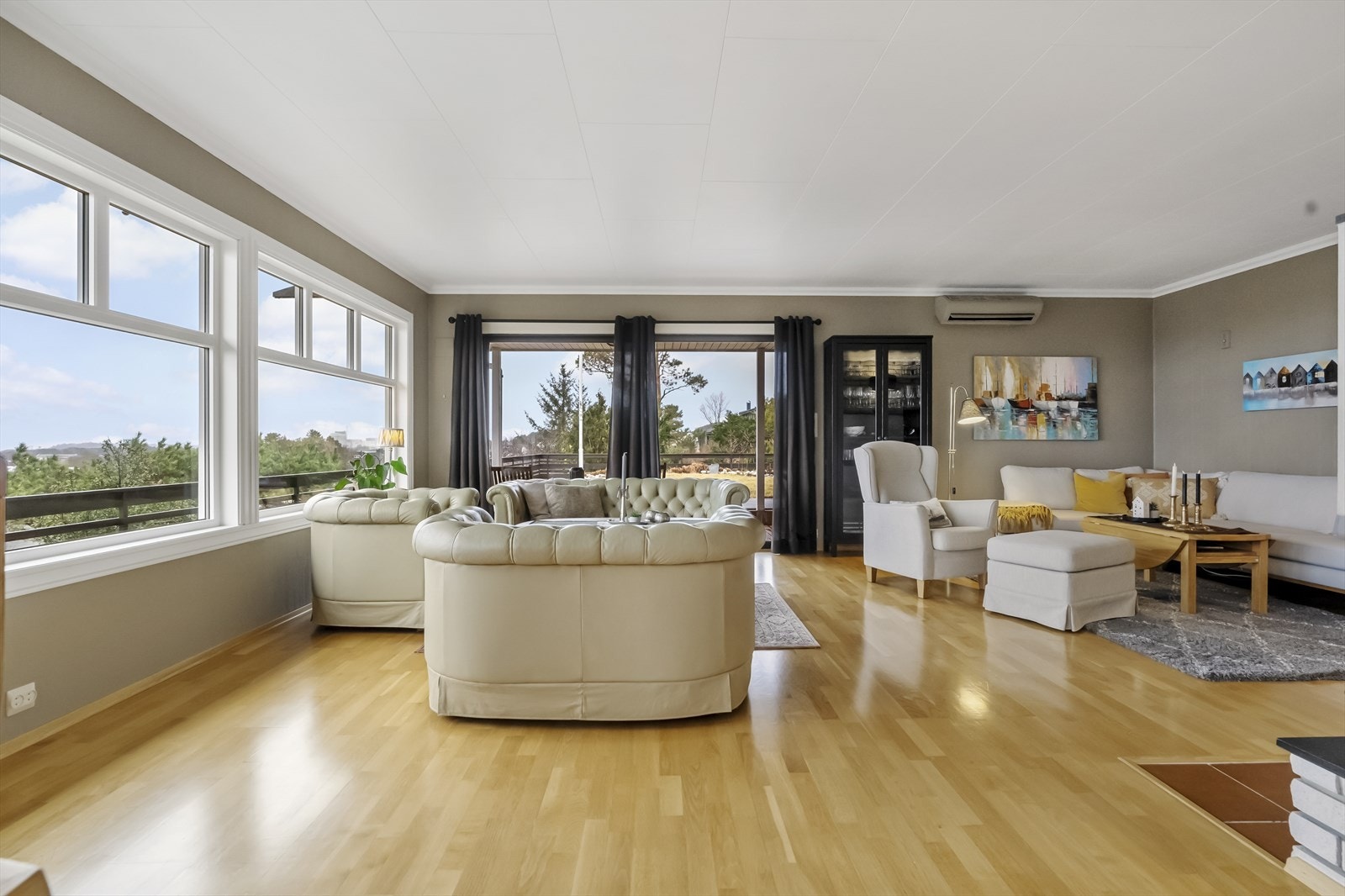 Stova er delt inn i fleire soner. Her det god plass til fleire sofagrupper og utgang til hage. Galleribilde