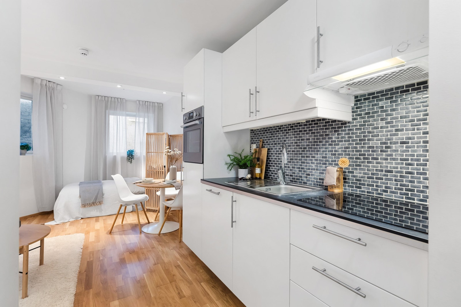 Moderne kjøkken med hvite glatte fronter og integrerte hvitevarer. Galleribilde