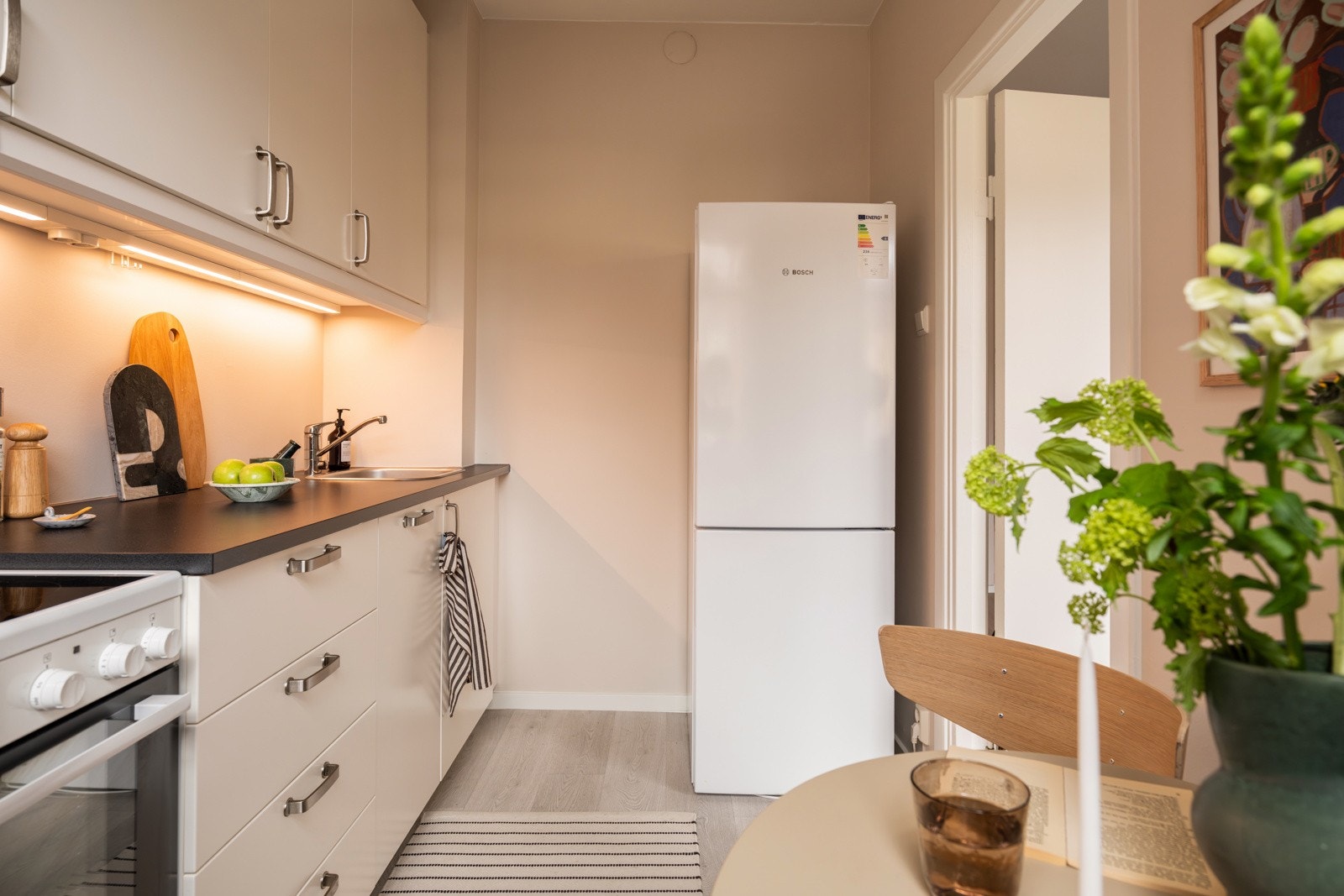 Kjøkkenet er utstyrt med medfølgende hvitevarer som komfyr, integrert oppvaskmaskin og frittstående kjøleskap med frysedel. Det er kjøkkenventilator med kullfilter. Alle hvitevarer medfølger. Galleribilde