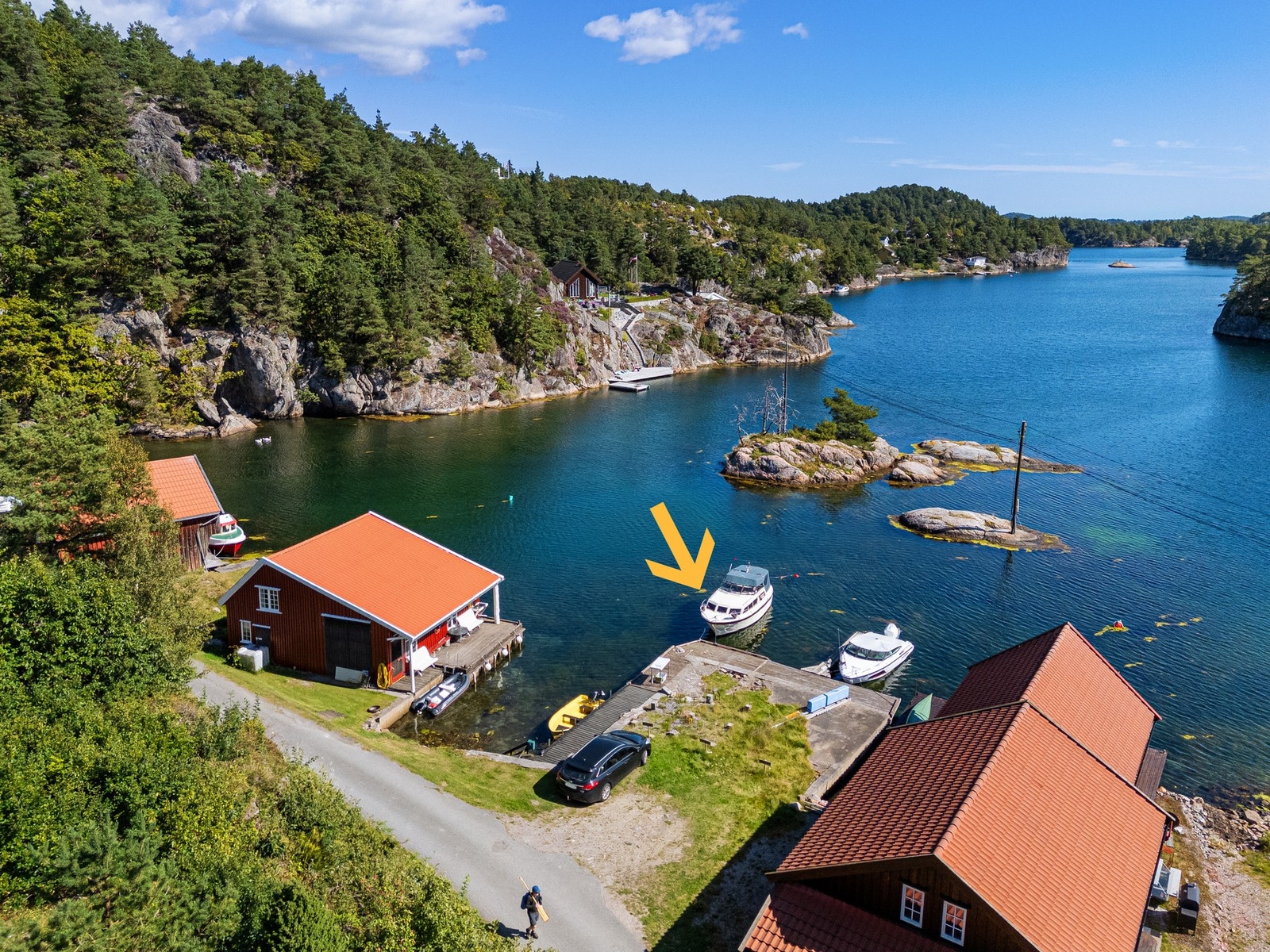 Bilde fra strandsonen hvor eier har rettighet til båtplass og parkeringsplass - pil mot båtplassen Galleribilde