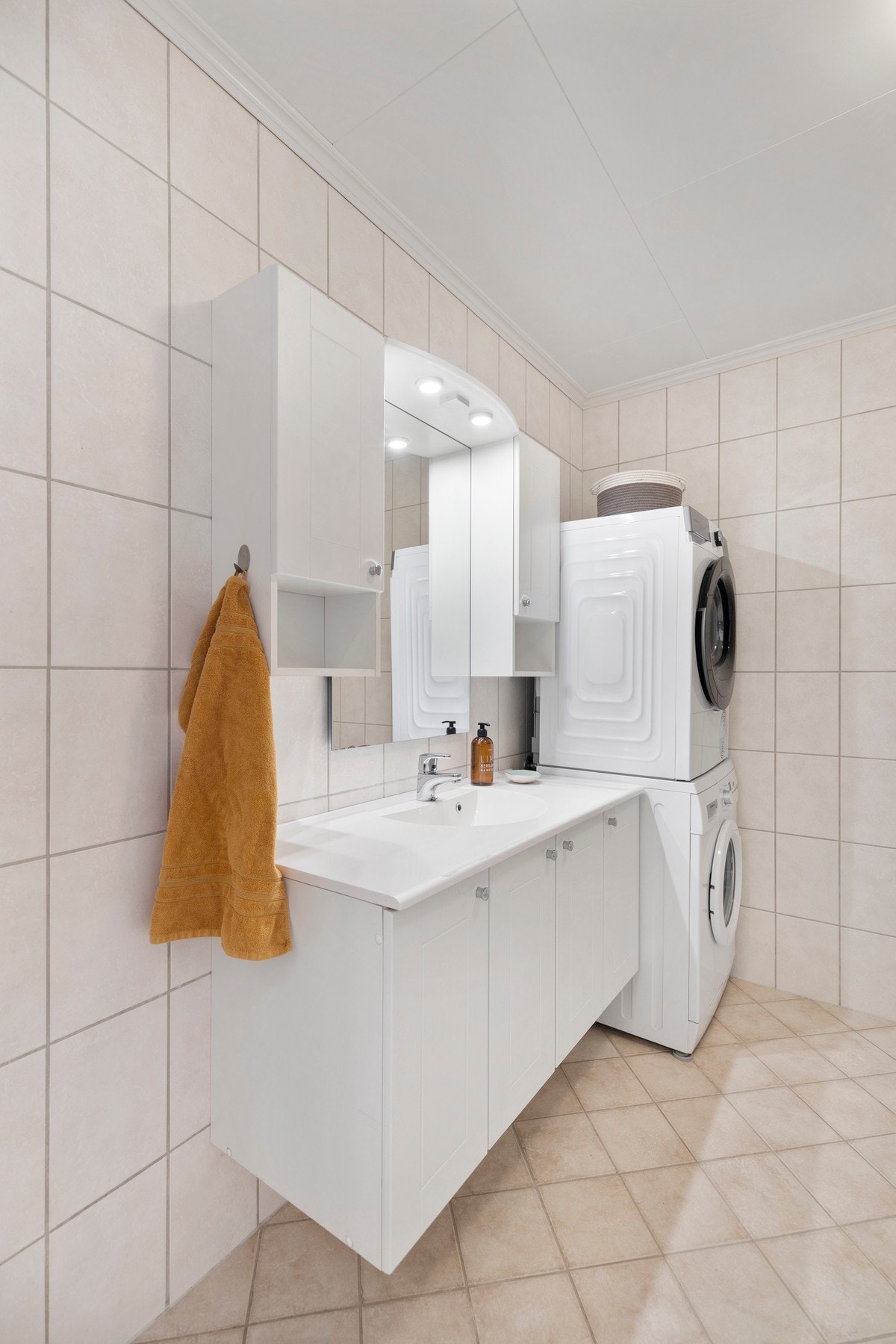 Badet inneholder videre dusjkabinett, toalett og baderomsinnredning med servant. Rommet har opplegg for vaskemaskin og tørketrommel. Galleribilde