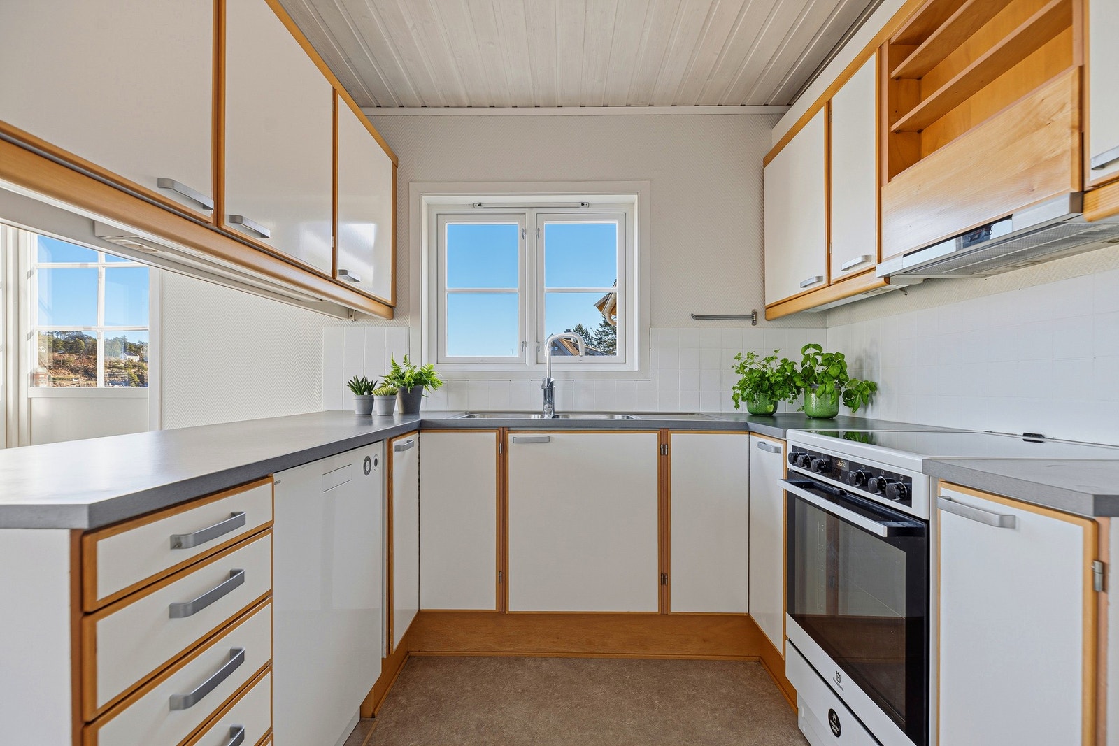 Innredningen har rikelig med skap og skuffer, benkeplate i laminat og nedfelt oppvaskkum samt hvitevarer som komfyr og oppvaskmaskin. Galleribilde