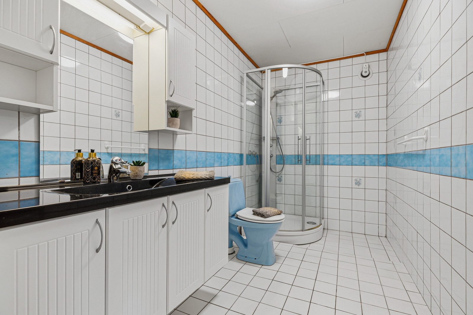 Badet i underetasjen har fliser og gulvvarme. Rommet har nyere innredning, dusjkabinett og toalett Galleribilde