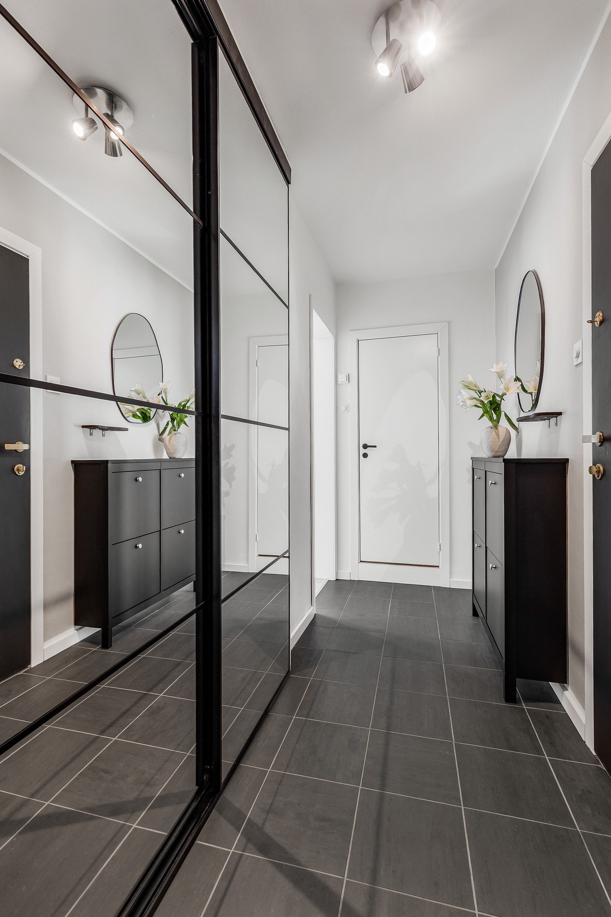 Det er montert en romslig skyvedørsgarderobe med speilfronter for oppbevaring av yttertøy og sko Galleribilde