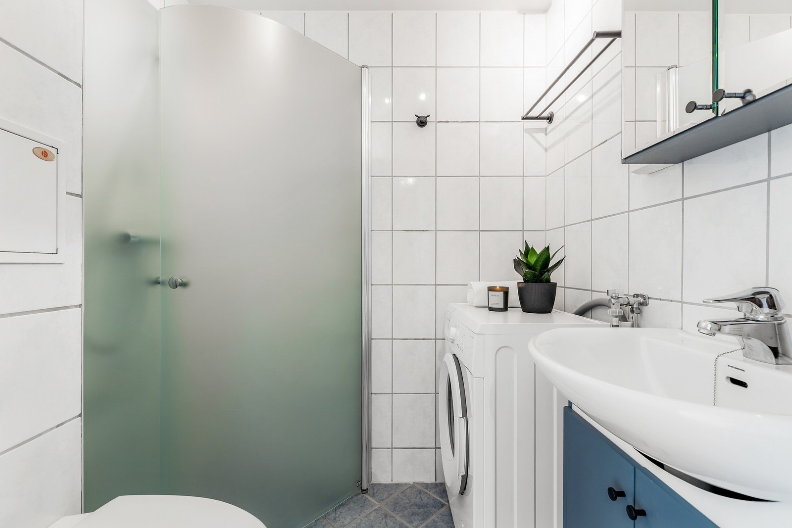 Badet er helfliset og innredet med bl.a. vegghengt toalett, servantskap og dusjhjørne Galleribilde