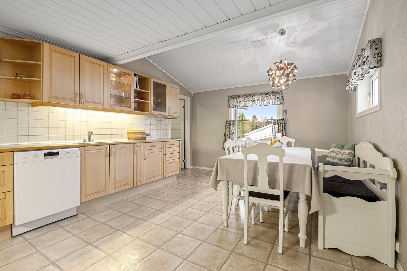 Innredningen er av laminert/finert utførelse med profilerte fronter i heltre og laminat benkeplate med nedfelt induksjonstopp. Galleribilde