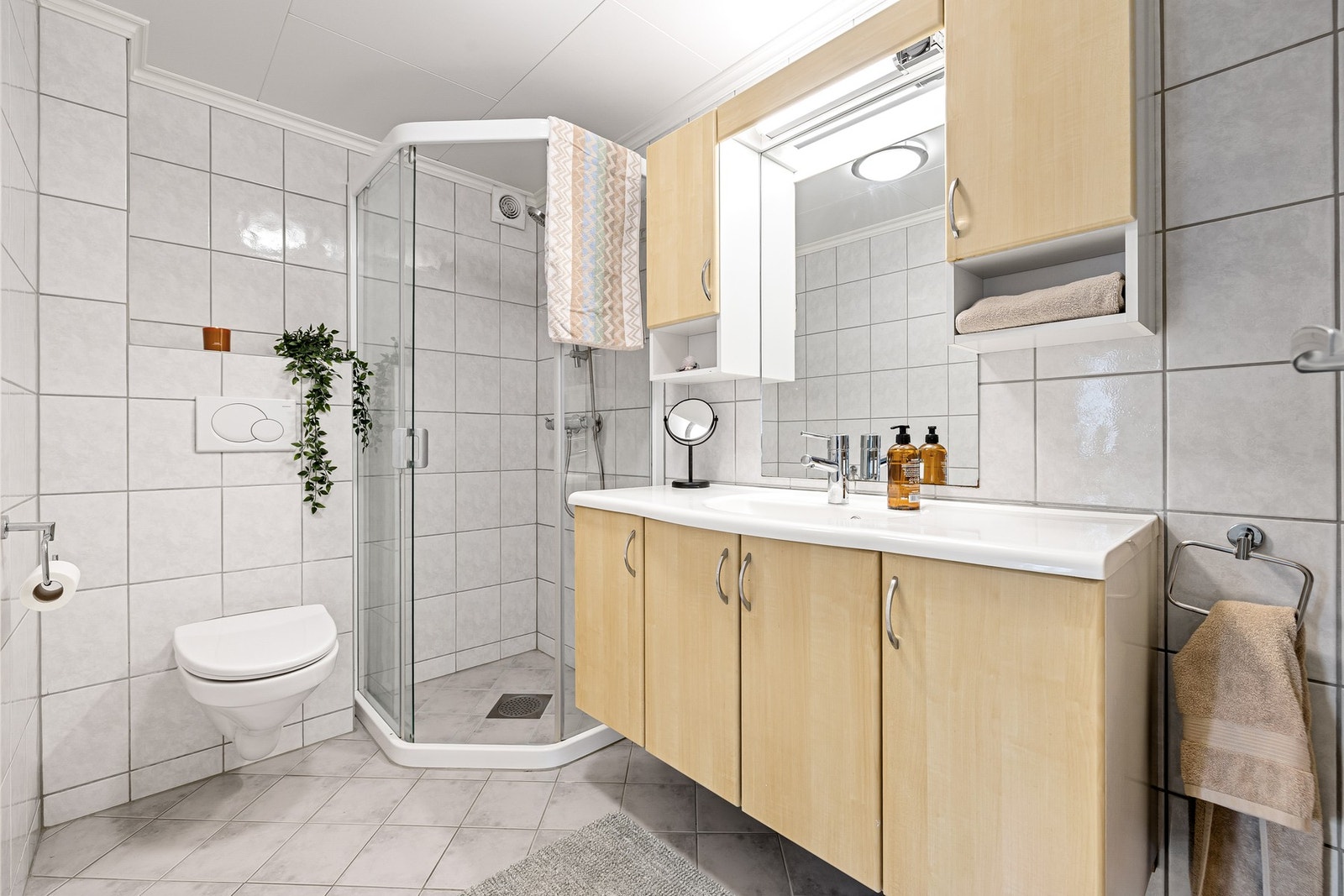 Boligen har et praktisk hovedbad som vist her i 1. etasje på 4,5 kvm, i tillegg til et separat WC i 2. etasje. Flis på gulv og vegger med gulvvarme. Galleribilde