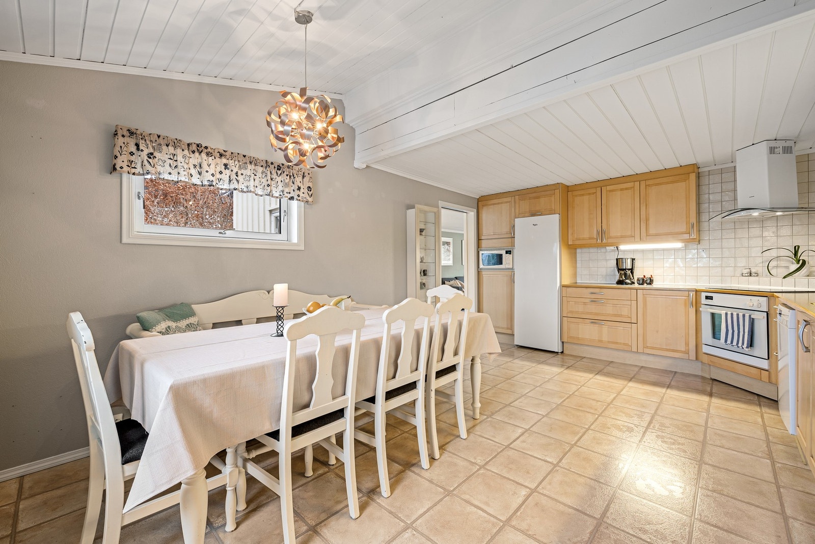 Lyst og generøst kjøkken på 20 kvm, med god takhøyde og slitesterke laminatfliser som gir en praktisk og helhetlig overflate. Galleribilde