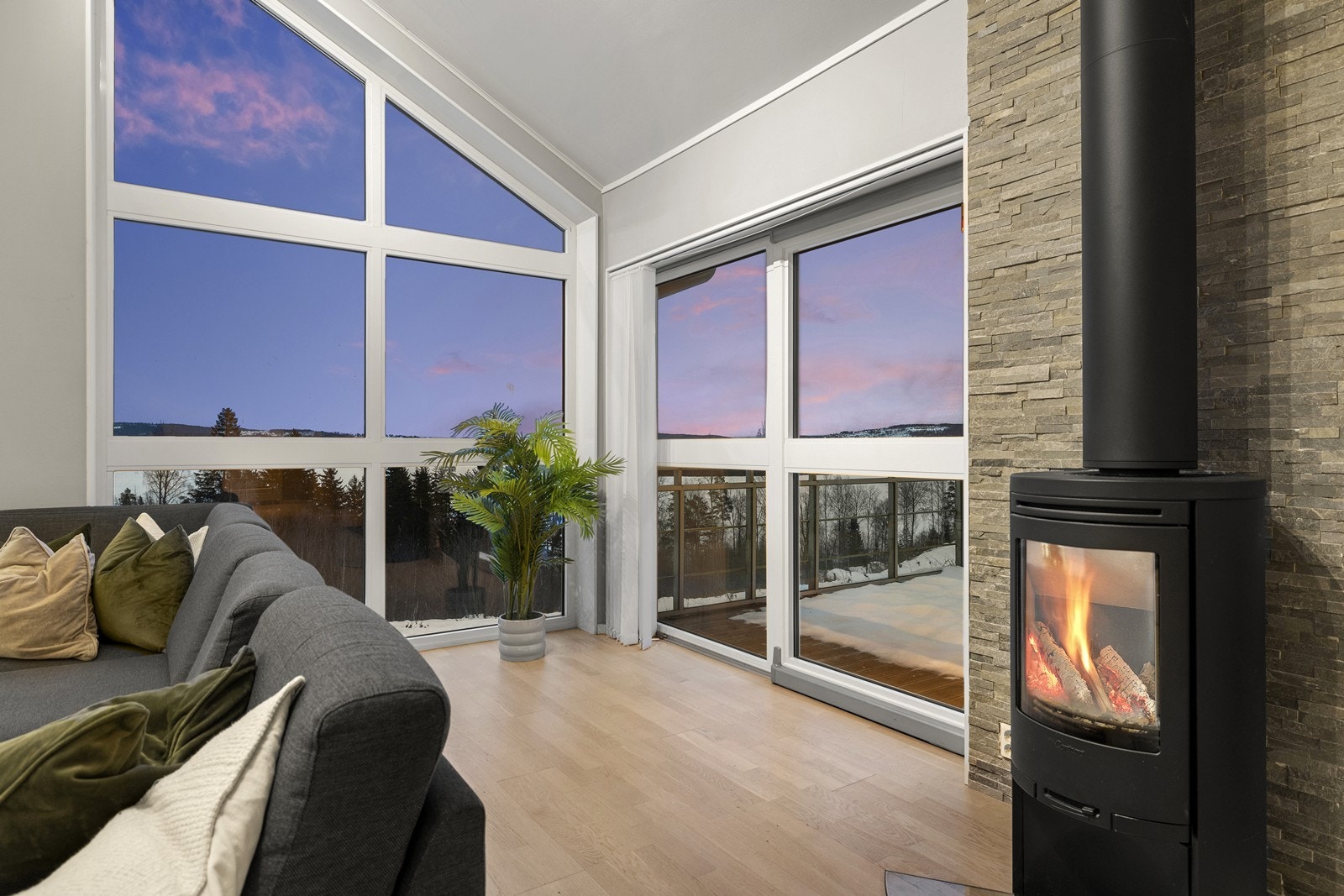 De store vindusflatene gir nydelig utsikt og slipper naturen inn, mens peisen skaper en varm og stemningsfull atmosfære. Galleribilde