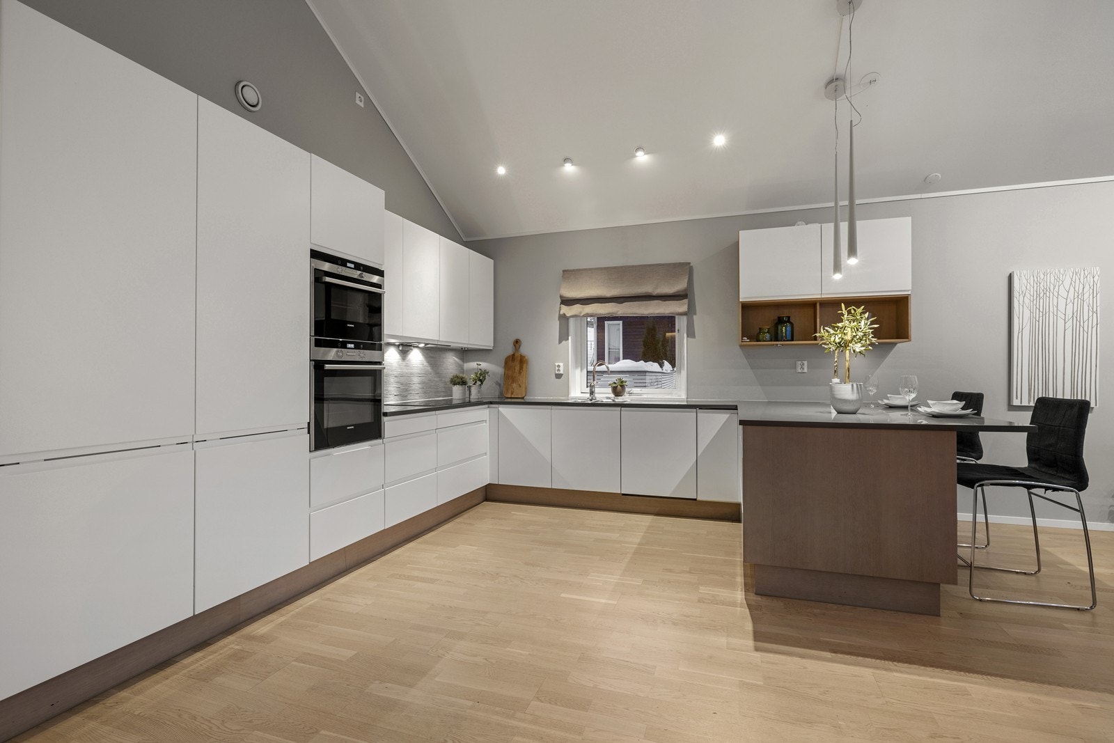 Rikelig med skap- og benkeplass i en funksjonell U-løsning gjør kjøkkenet til et sosialt samlingspunkt hvor hele familien kan delta i matlagingen. Galleribilde