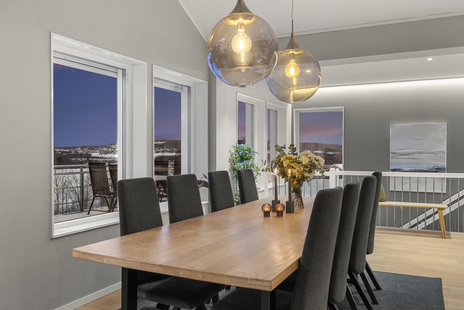 Romslig og lys spisestue med plass til hele storfamilien. Store vinduer og stemningsfull belysning danner en perfekt ramme for hyggelige måltider med venner og familie. Galleribilde