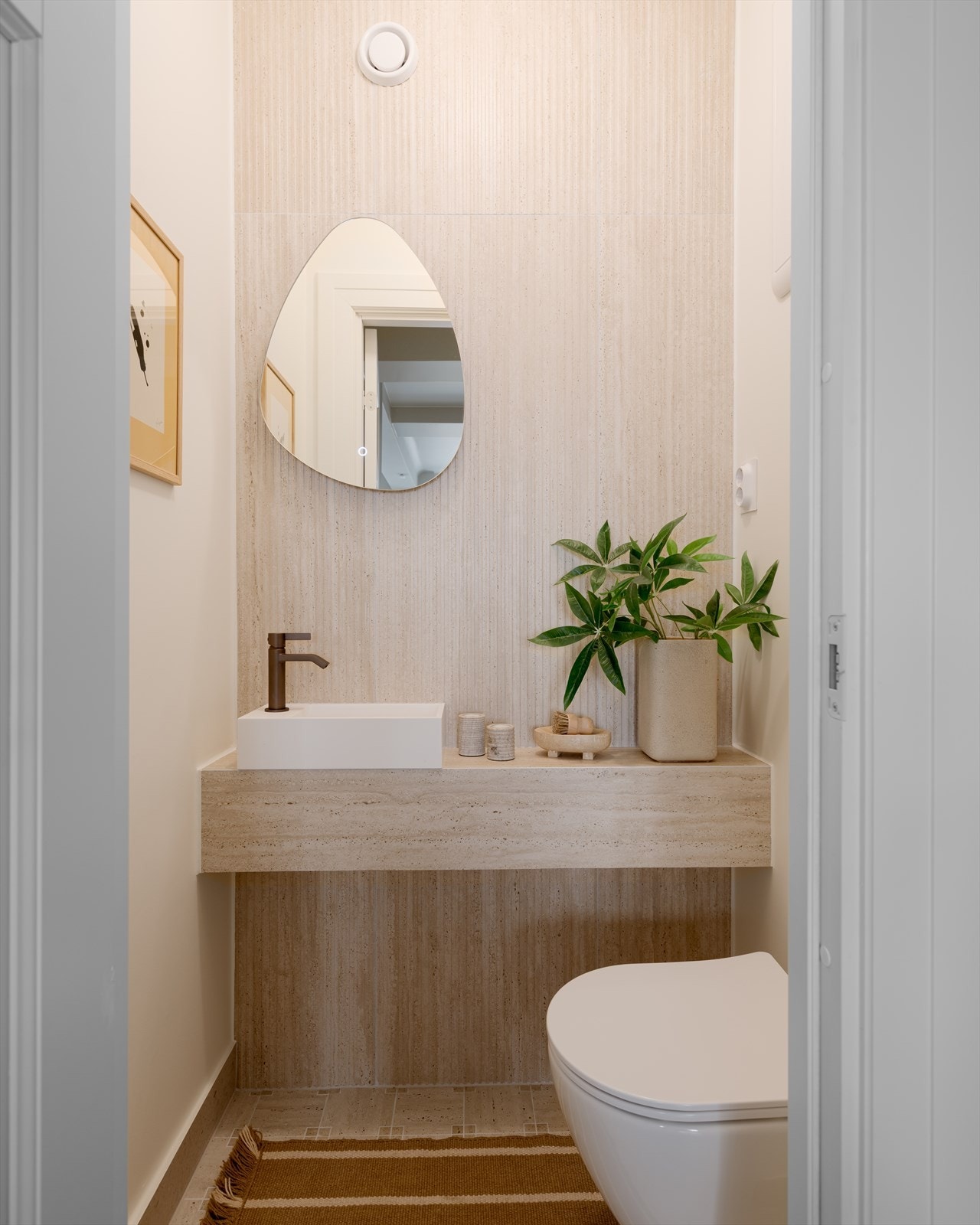 Sep. wc. Rommet er belagt med italienske fliser i travertinimitasjon på gulv, med delvis flislagte og delvis malte vegger. Galleribilde