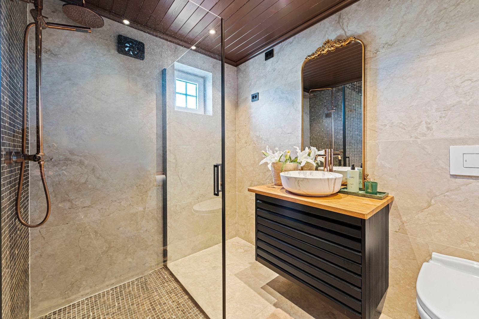 Innredet med servantinnredning, dusjdører og wc. Galleribilde