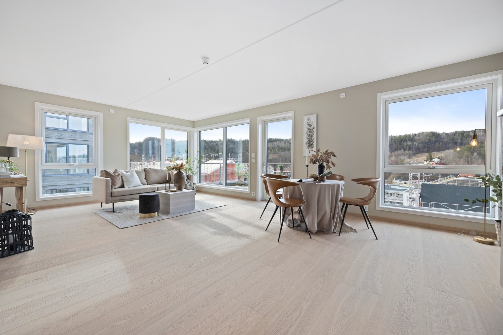 Lys og stor stue, mange vinduer og god takhøyde gir en fin atmosfære i leiligheten Galleribilde