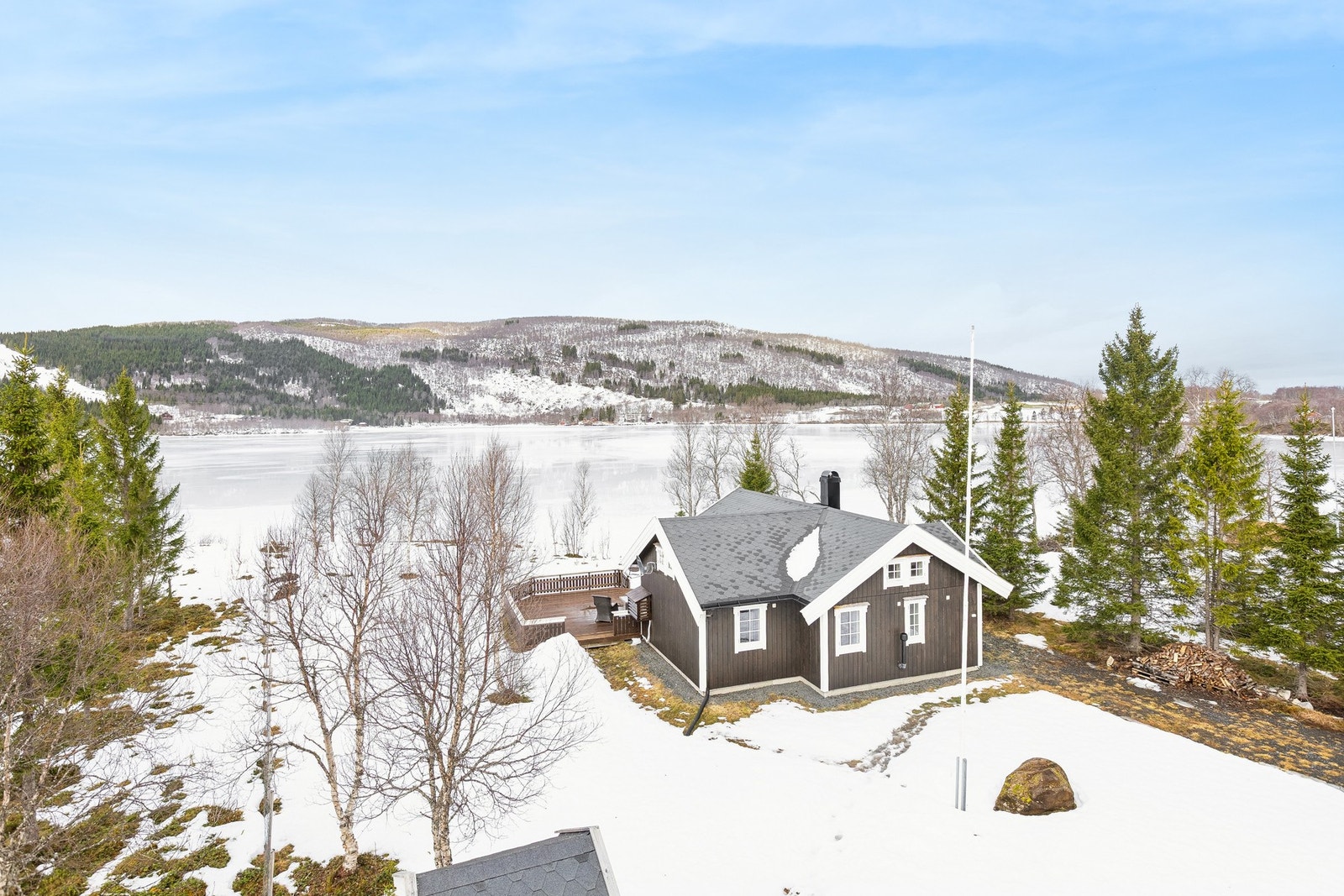 Tomten på ca 1.856 kvm er "innrammet" med koselige grantrær. Galleribilde