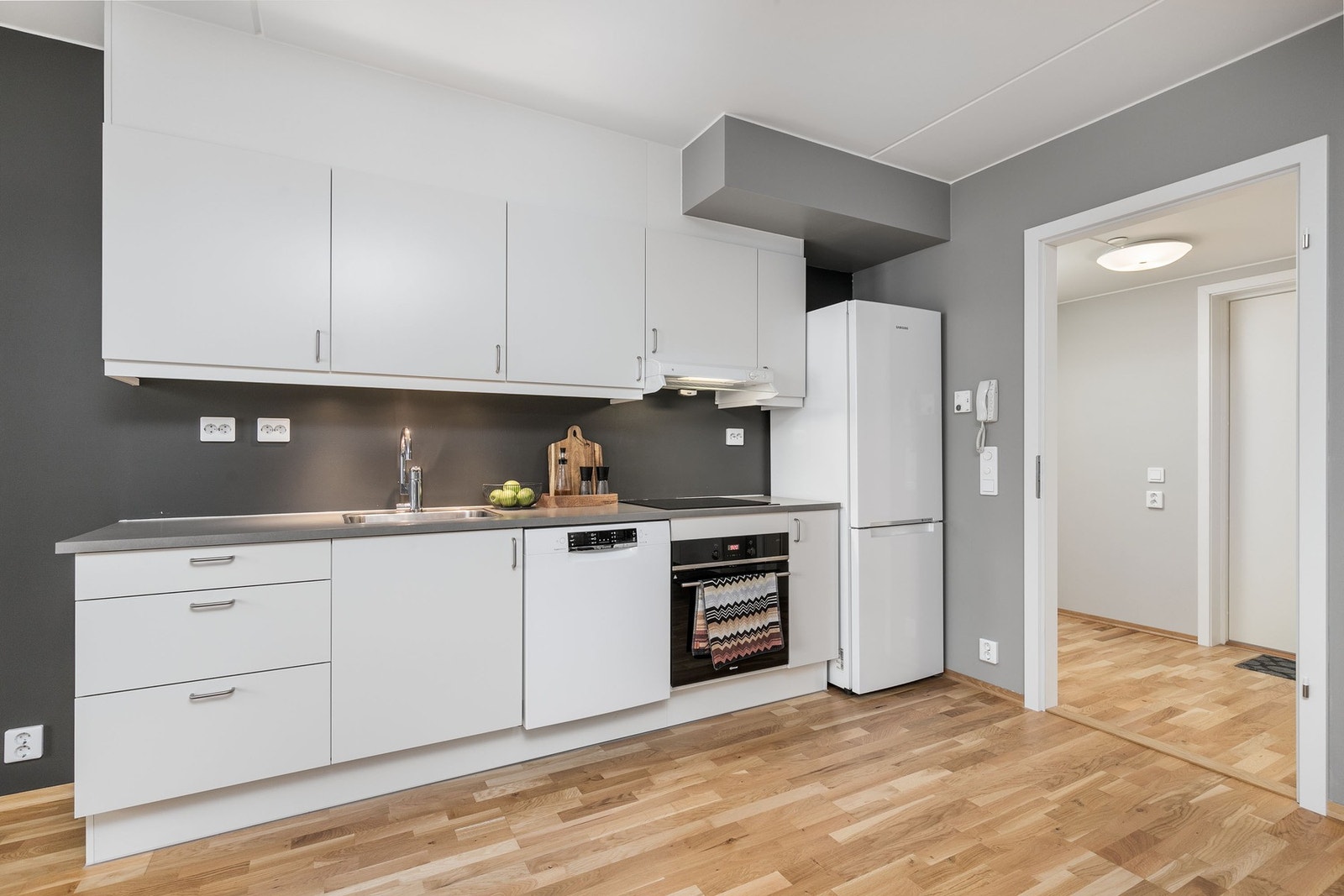 Innredningen har glatte fronter og laminert benkeplate med nedfelt oppvaskkum i stål. Galleribilde
