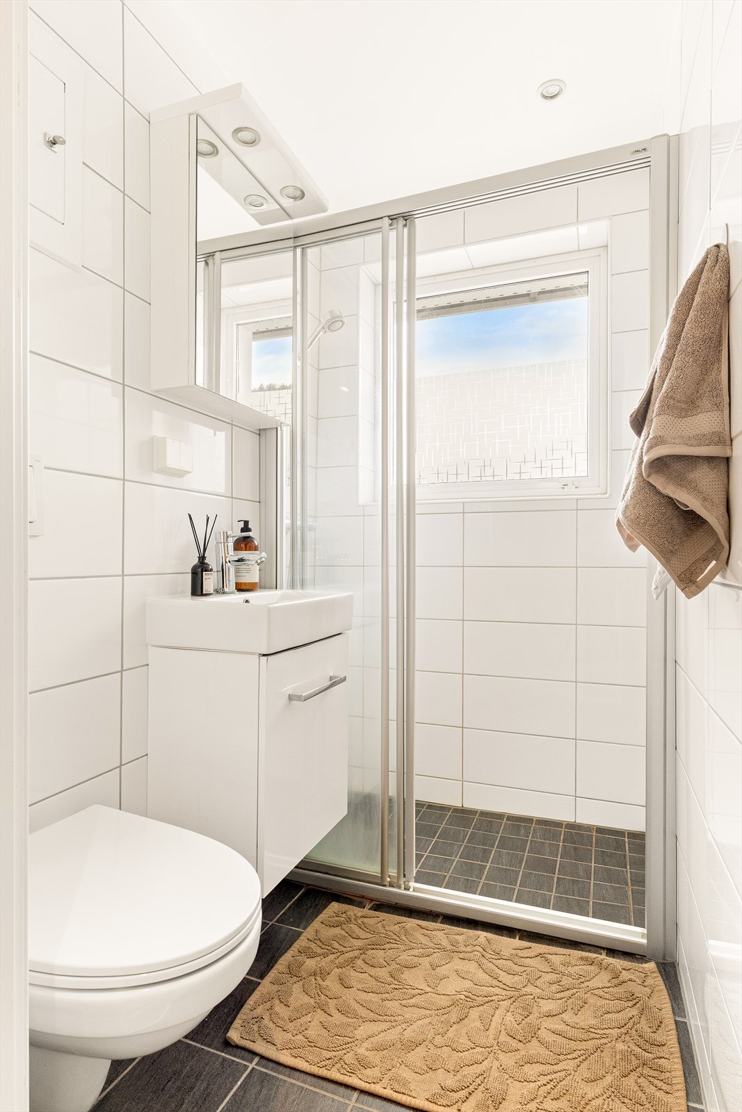 - Badet er innredet med heldekkende servant, vegghengt toalett og dusjvegg. Det er varmekabler i gulv. - Galleribilde