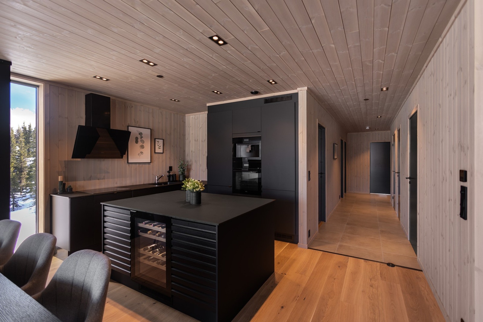 Kjøkkenet er lekkert og gjennomført, med sorte fronter i en kombinasjon av glatte og profilerte uttrykk, samt benkeplate i kompaktlaminat. Galleribilde