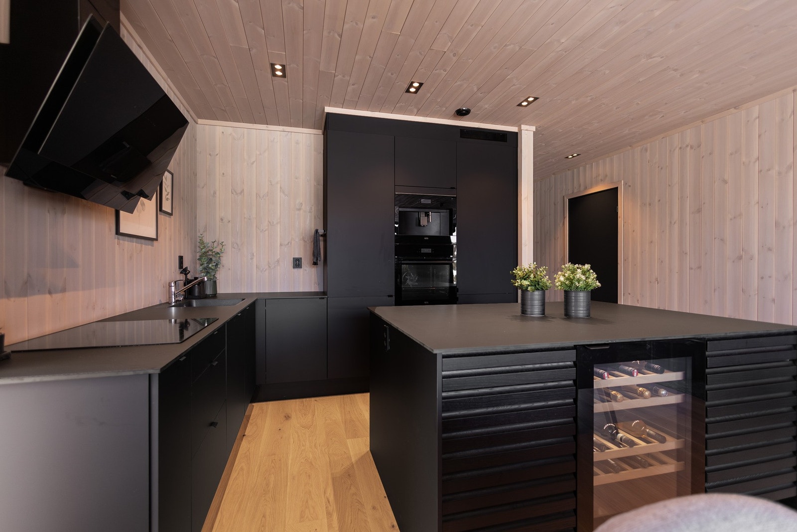 Kjøkkenet er fullt utstyrt med integrerte hvitevarer, herunder kjøl/frys, oppvaskmaskin, stekeovn, induksjonstopp, vinskap og kaffemaskin, samt praktiske løsninger som vannstoppsystem og komfyrvakt. Galleribilde