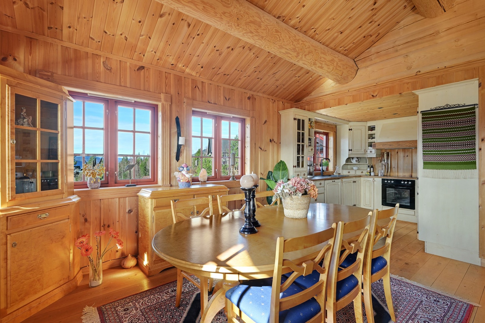 Koselig og sjarmerende kjøkken med spiseplass, gjennomført trepanel og rikelig med naturlig lys fra flere vinduer - perfekt for hyggelige måltider med utsikt. Galleribilde