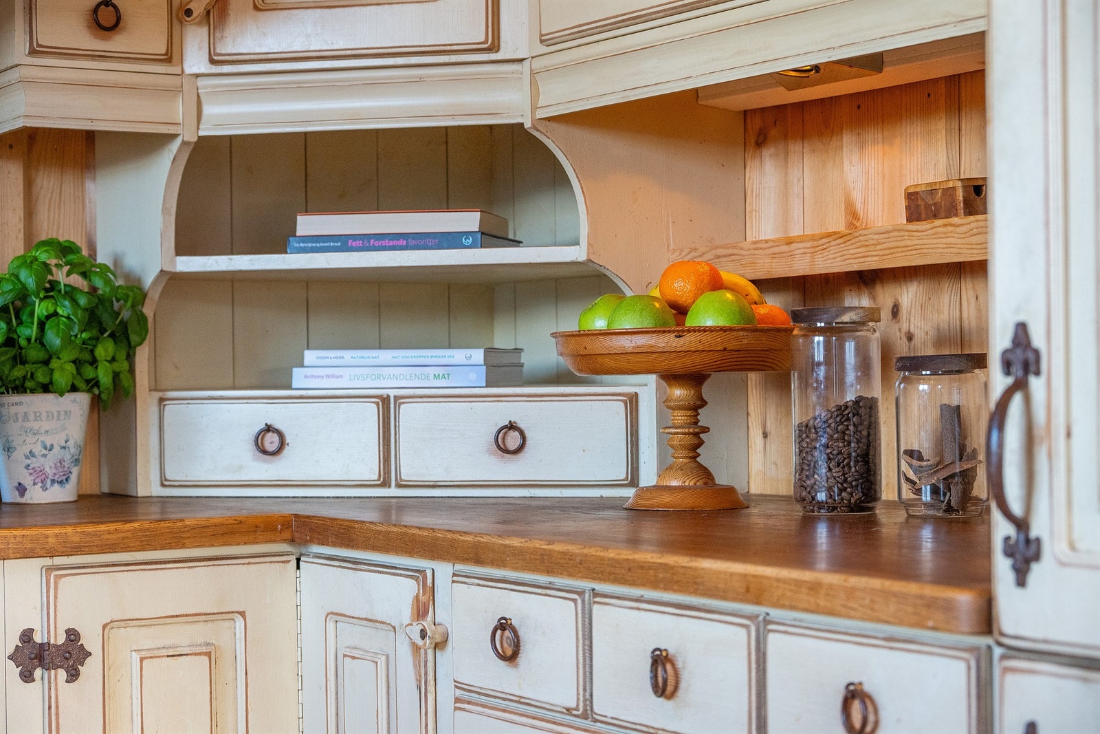 Sjarmerende kjøkkendetaljer med hyttepreg - gode arbeidsflater, dekorative hyller og praktisk oppbevaring som gir rommet både varme og funksjonalitet. Galleribilde