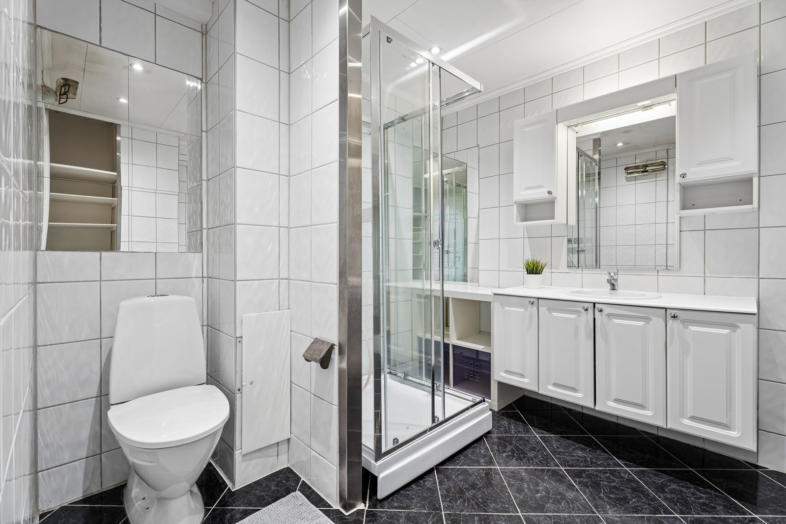 Badet er utstyrt med gulvmontert toalett og stråleovn på vegg. Galleribilde