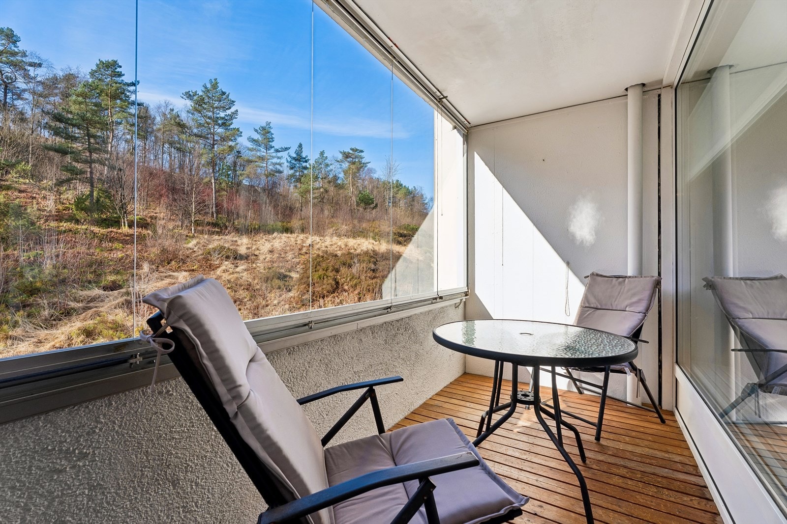 Innglasset balkong på ca. 6 m² med tregulv. Innglassingen forlenger brukstiden og skaper en lun uteplass. Galleribilde