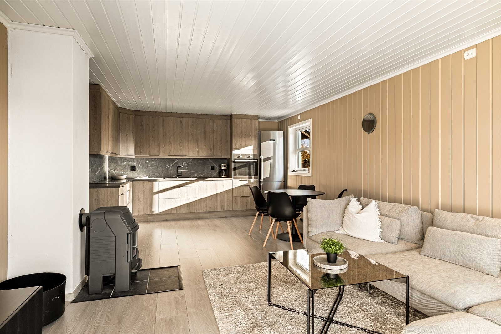 Leiligheten har et gjennomført og stilrent uttrykk med nydelig laminatgulv som gir en lun og moderne følelse. Vegger og himling er kledd i flott malt panel som tilfører både karakter og varme til rommene. Galleribilde