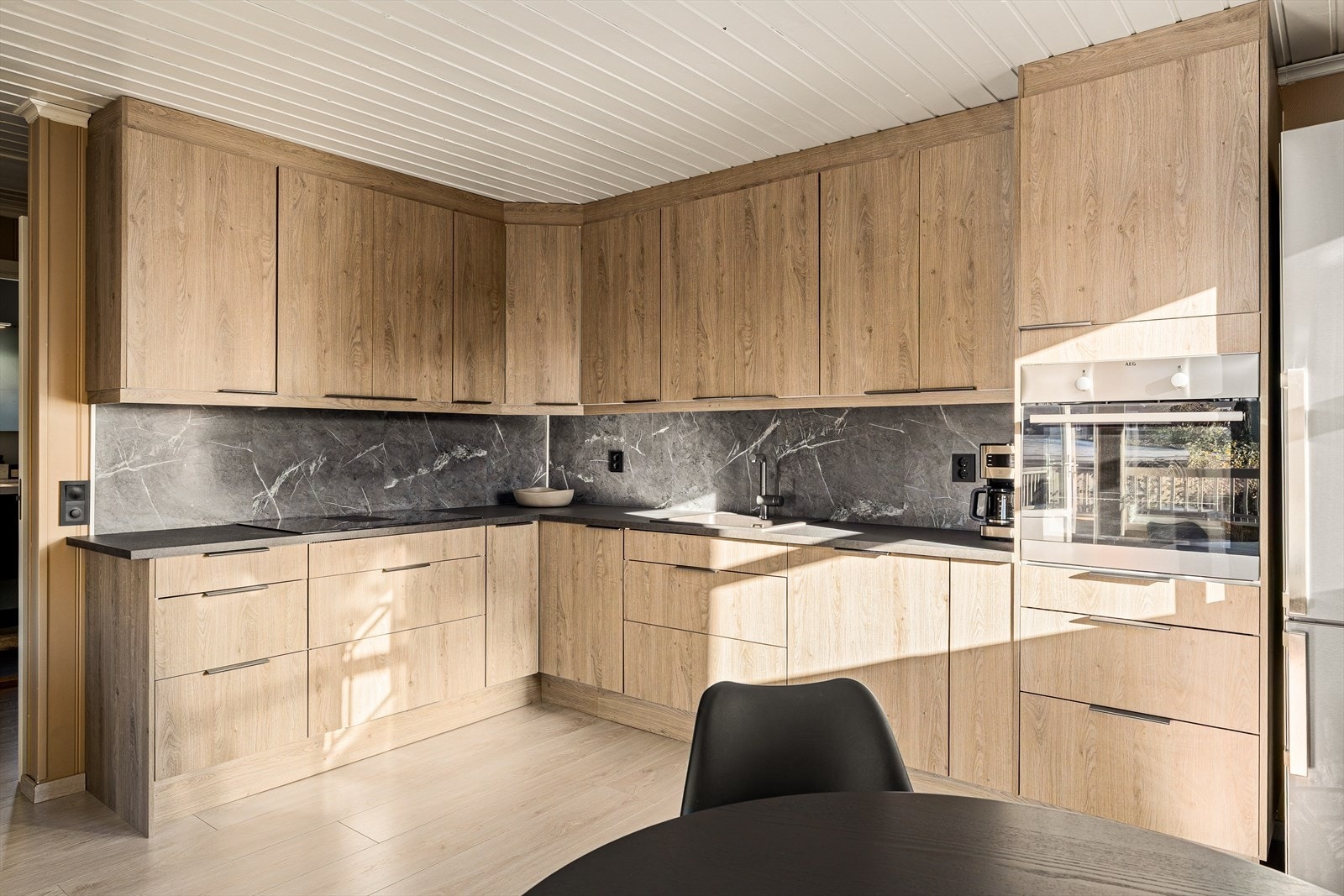 Kjøkkenet er både funksjonelt og stilrent, med rikelig skapplass og gode benkeflater som gjør matlagingen til en lek. Integrerte hvitevarer gir et helhetlig uttrykk og bidrar til en ryddig og moderne kjøkkenopplevelse. Galleribilde