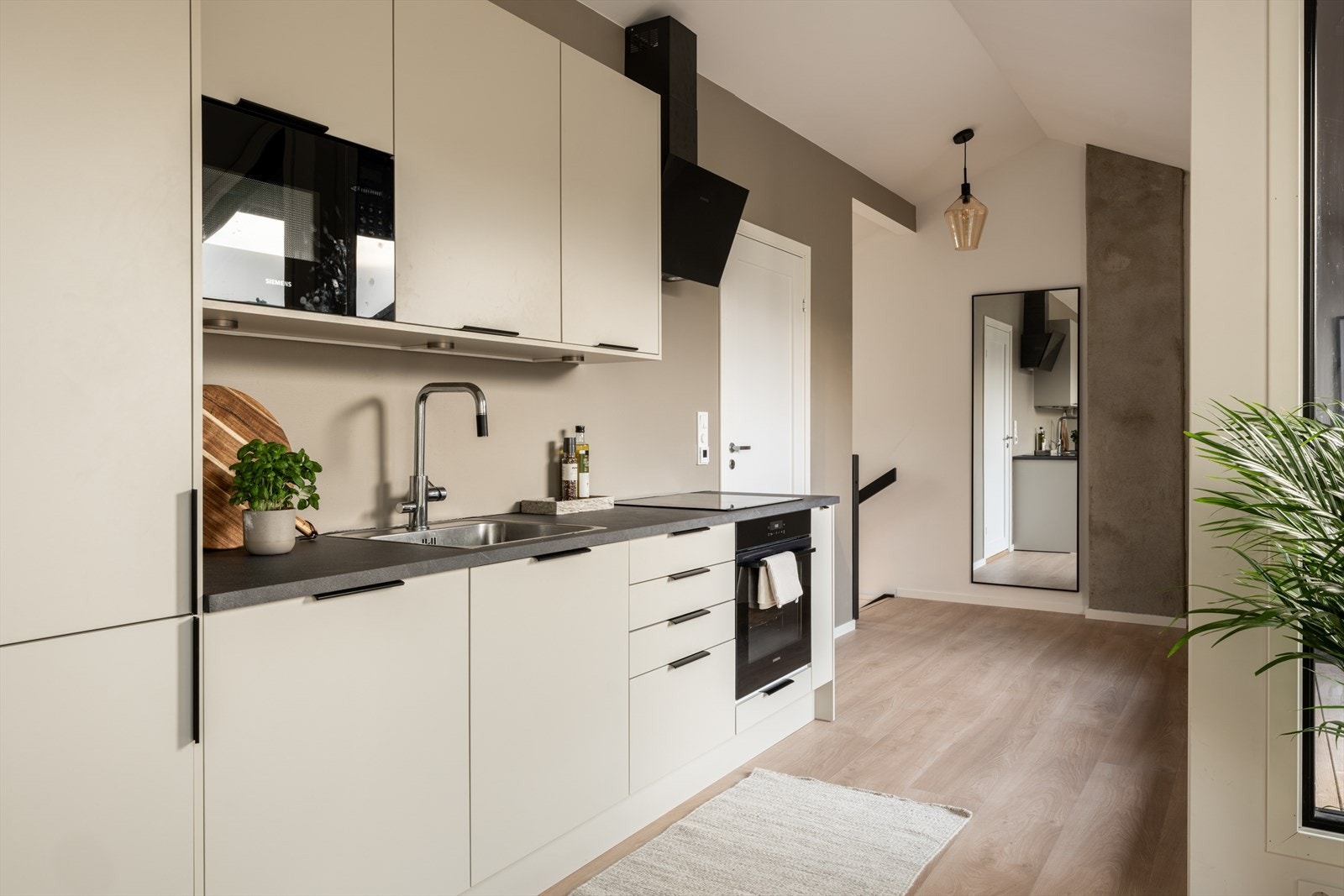 Kjøkkenet har moderne innredning med glatte skapfronter og laminat benkeplate. Galleribilde
