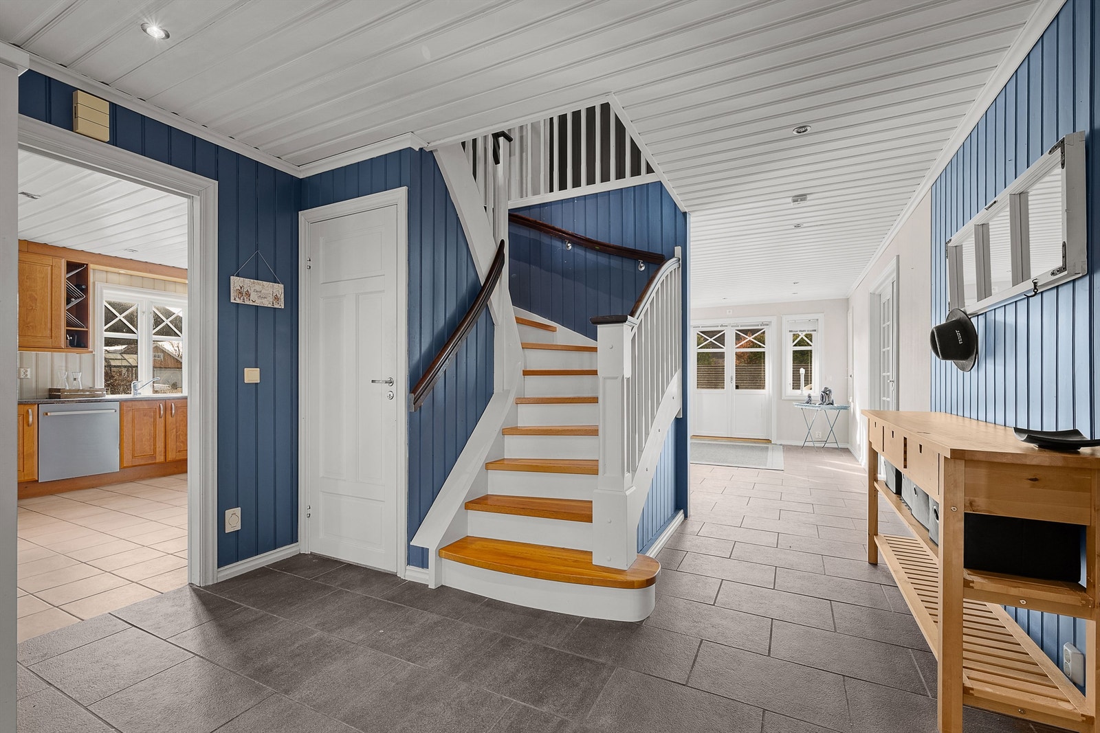 Hallen fungerer som et bindeledd med tilgang til kjøkken, stuer og trapp til de øvrige etasjene. Galleribilde